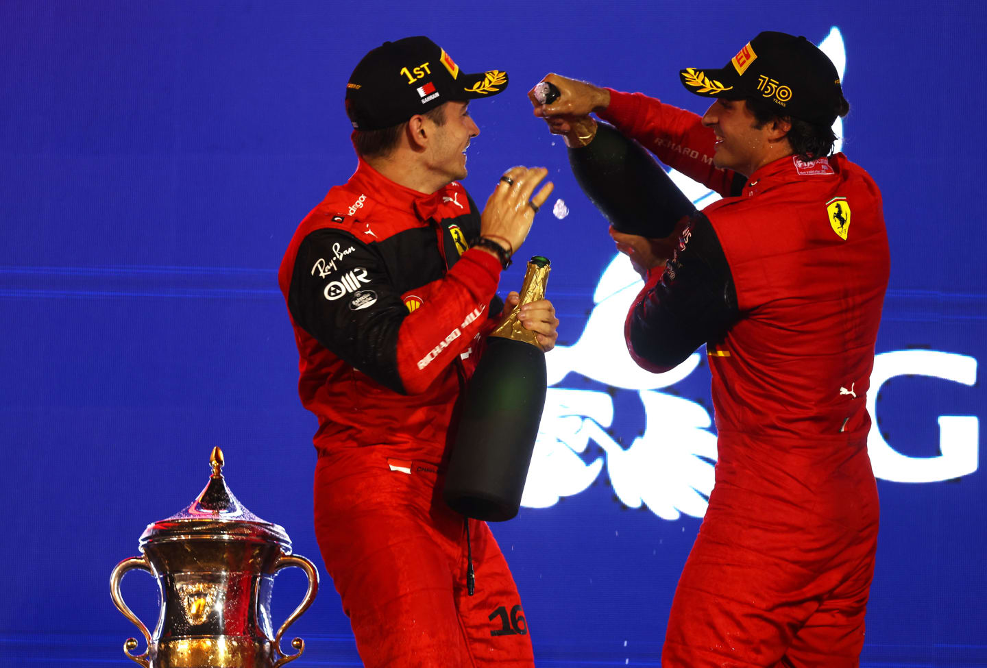 BAHRAIN, BAHRAIN - MARCH 20: Race winner Charles Leclerc of Monaco and Ferrari and Second placed Carlos Sainz of Spain and Ferrari celebrate on the podium during the F1 Grand Prix of Bahrain at Bahrain International Circuit on March 20, 2022 in Bahrain, Bahrain. (Photo by Lars Baron/Getty Images)
