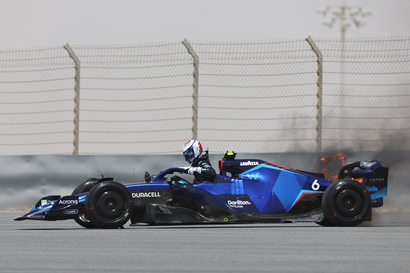 BAHRAIN, BAHRAIN - MARCH 11: Nicholas Latifi of Canada and Williams climbs from his car as his rear brakes catch fire during Day Two of F1 Testing at Bahrain International Circuit on March 11, 2022 in Bahrain, Bahrain. (Photo by Mark Thompson/Getty Images)