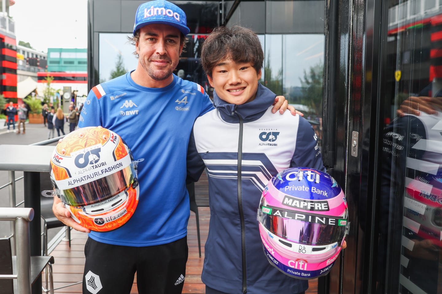 SPA, BELGIUM - AUGUST 27: Fernando Alonso of Alpine F1 and Spain and Yuki Tsunoda of Scuderia AlphaTauri and Japan swap crash helmets during qualifying ahead of the F1 Grand Prix of Belgium at Circuit de Spa-Francorchamps on August 27, 2022 in Spa, Belgium. (Photo by Peter Fox/Getty Images)