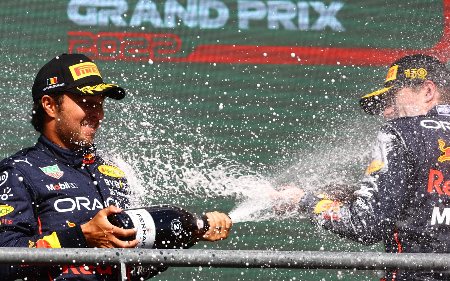 SPA, BELGIUM - AUGUST 28: Race winner Max Verstappen of the Netherlands and Oracle Red Bull Racing and Second placed Sergio Perez of Mexico and Oracle Red Bull Racing celebrate on the podium during the F1 Grand Prix of Belgium at Circuit de Spa-Francorchamps on August 28, 2022 in Spa, Belgium. (Photo by Mark Thompson/Getty Images)