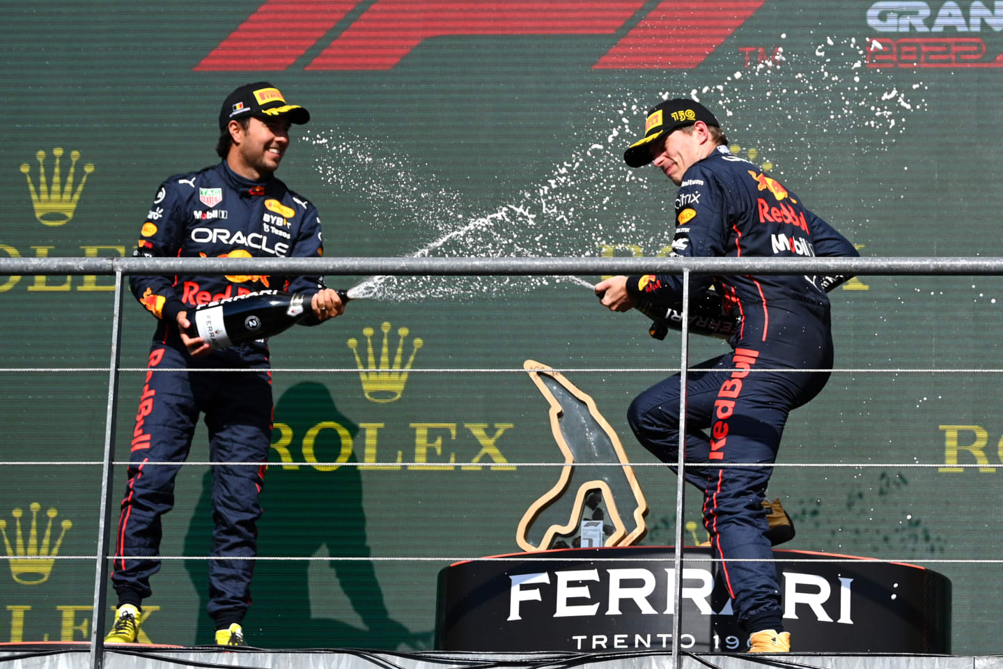 SPA, BELGIUM - AUGUST 28: Race winner Max Verstappen of the Netherlands and Oracle Red Bull Racing and Second placed Sergio Perez of Mexico and Oracle Red Bull Racing celebrate on the podium during the F1 Grand Prix of Belgium at Circuit de Spa-Francorchamps on August 28, 2022 in Spa, Belgium. (Photo by Dan Mullan/Getty Images)