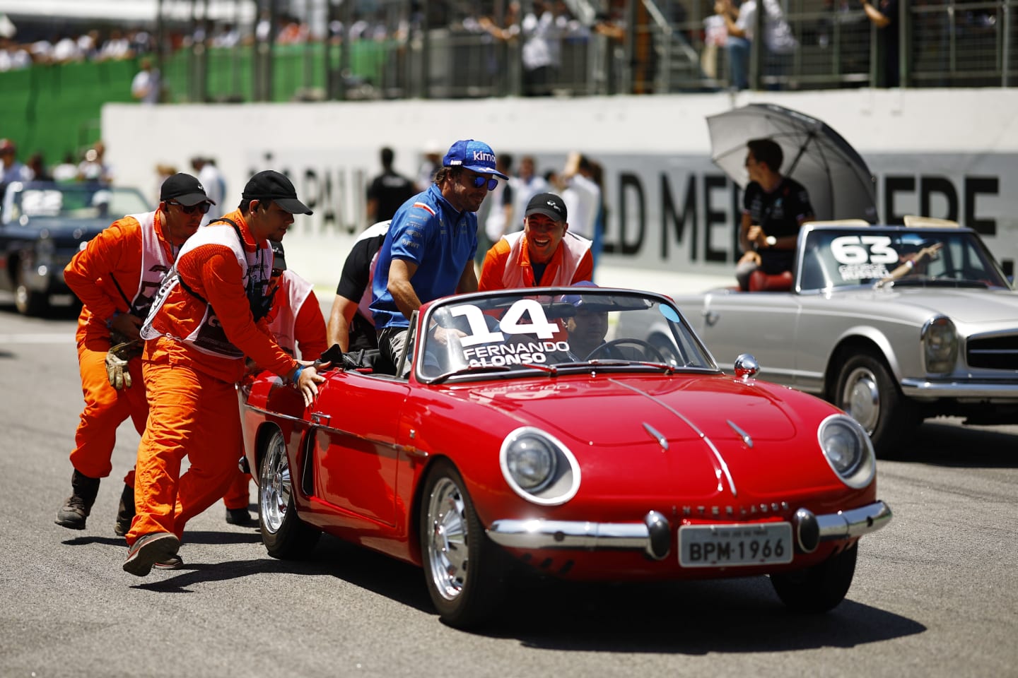 SAO PAULO, BRAZIL - NOVEMBER 13: Track marshals help Fernando Alonso of Spain and Alpine F1 as his car stops on the drivers parade prior to the F1 Grand Prix of Brazil at Autodromo Jose Carlos Pace on November 13, 2022 in Sao Paulo, Brazil. (Photo by Chris Graythen/Getty Images)