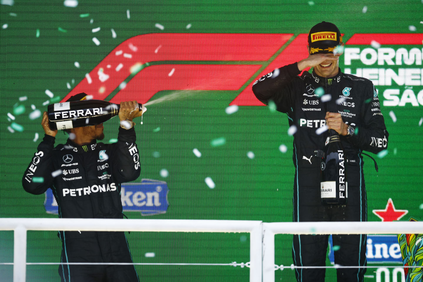 SAO PAULO, BRAZIL - NOVEMBER 13: Race winner George Russell of Great Britain and Mercedes and Second placed Lewis Hamilton of Great Britain and Mercedes celebrate on the podium during the F1 Grand Prix of Brazil at Autodromo Jose Carlos Pace on November 13, 2022 in Sao Paulo, Brazil. (Photo by Chris Graythen/Getty Images)