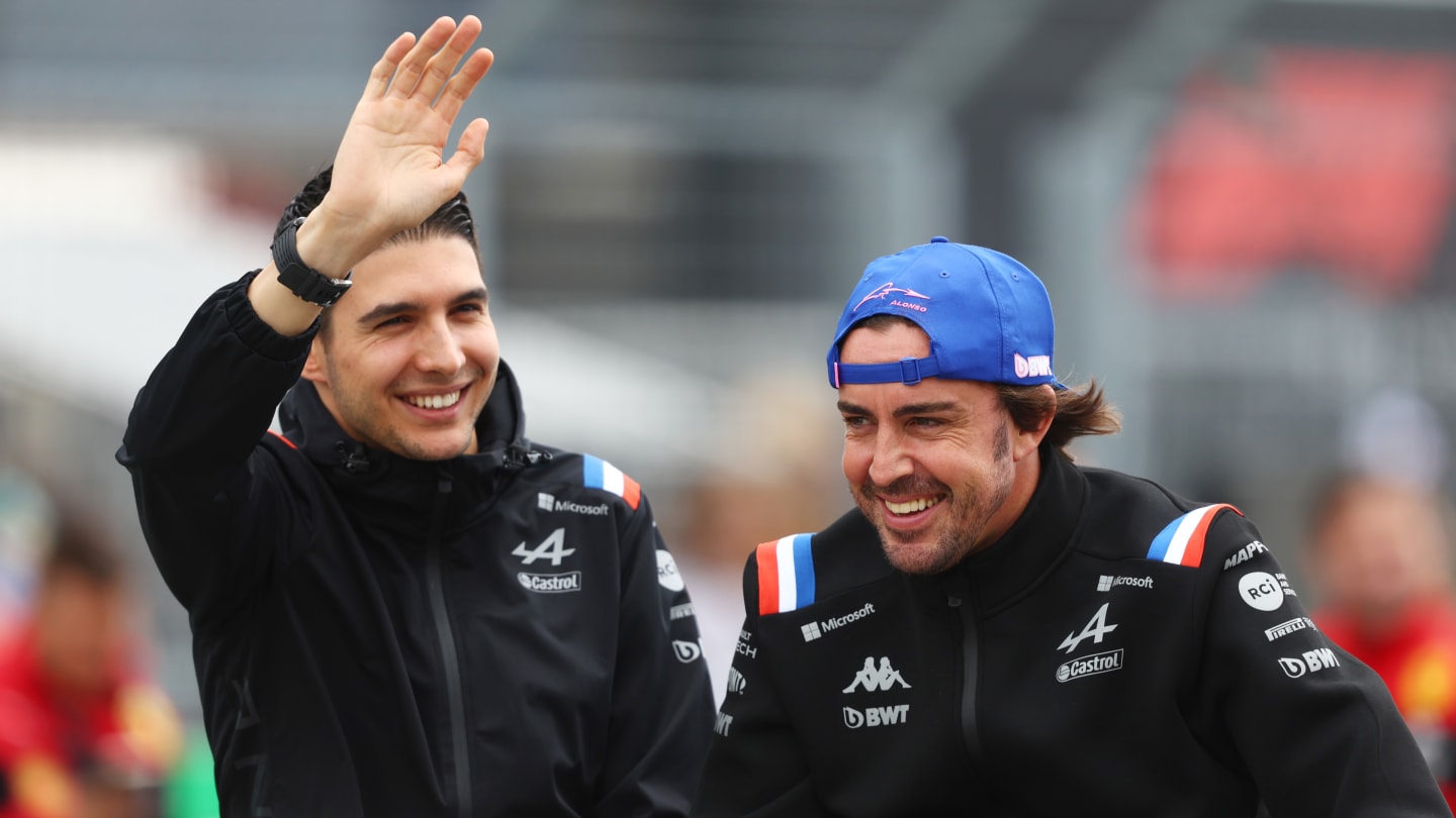 BUDAPEST, HUNGARY - JULY 31: Esteban Ocon of France and Alpine F1 waves as Fernando Alonso of Spain and Alpine F1 looks on from the drivers parade ahead of the F1 Grand Prix of Hungary at Hungaroring on July 31, 2022 in Budapest, Hungary. (Photo by Bryn Lennon - Formula 1/Formula 1 via Getty Images)