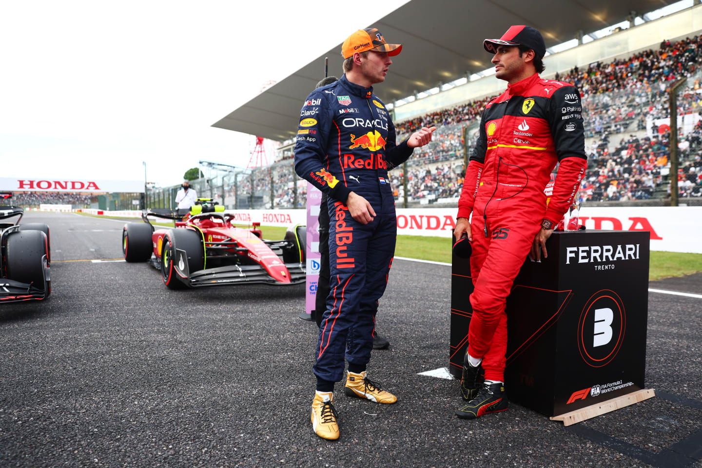 SUZUKA, JAPAN - OCTOBER 08: Pole position qualifier Max Verstappen of the Netherlands and Oracle Red Bull Racing and Third placed qualifier Carlos Sainz of Spain and Ferrari talk in parc ferme during qualifying ahead of the F1 Grand Prix of Japan at Suzuka International Racing Course on October 08, 2022 in Suzuka, Japan. (Photo by Dan Istitene - Formula 1/Formula 1 via Getty Images)