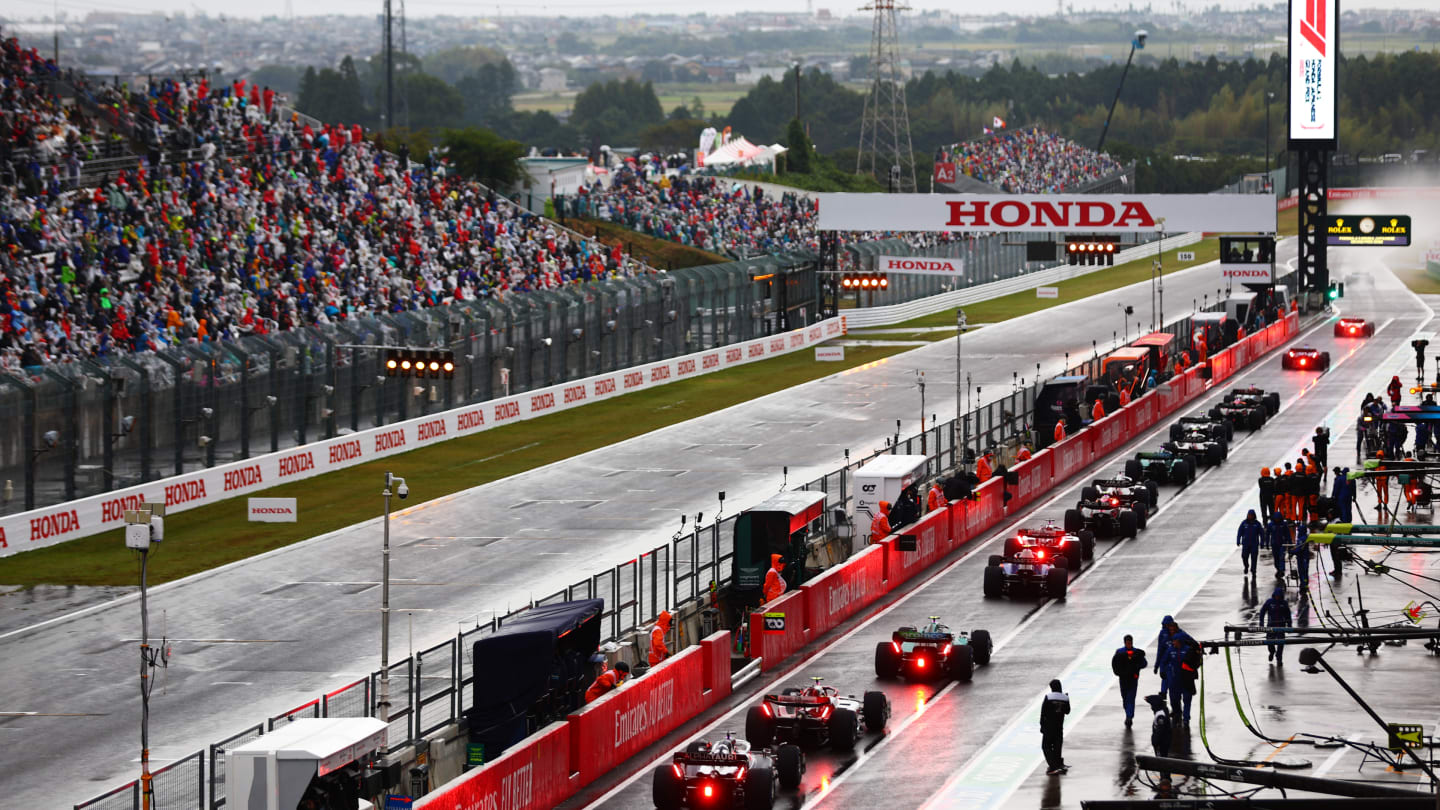 SUZUKA, JAPAN - OCTOBER 09: The field leave the pitlane for the restart following a red flag delay