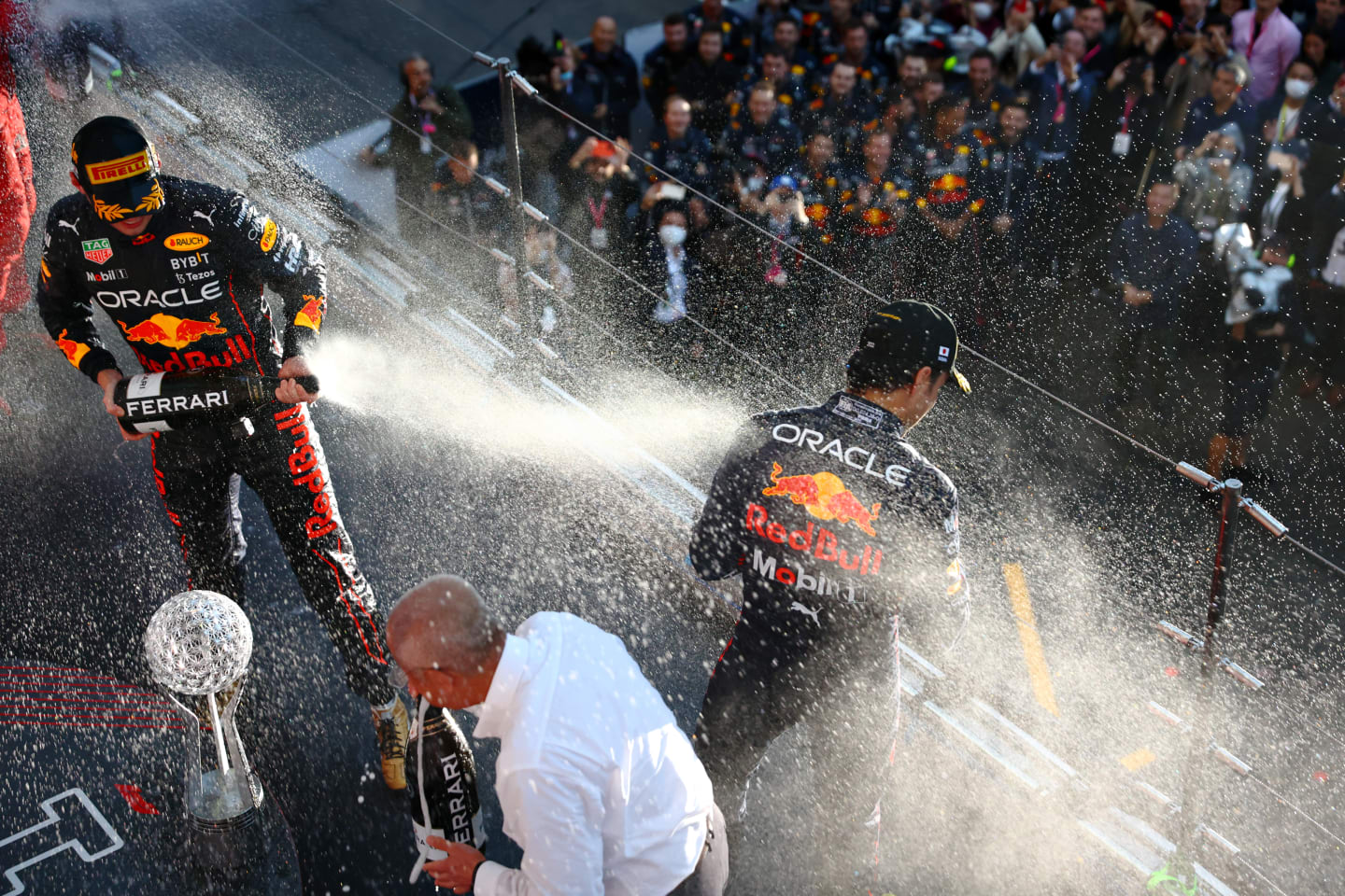 SUZUKA, JAPAN - OCTOBER 09: Race winner and 2022 F1 World Drivers Champion Max Verstappen of Netherlands and Oracle Red Bull Racing and Second placed Sergio Perez of Mexico and Oracle Red Bull Racing celebrate on the podium during the F1 Grand Prix of Japan at Suzuka International Racing Course on October 09, 2022 in Suzuka, Japan. (Photo by Mark Thompson/Getty Images )