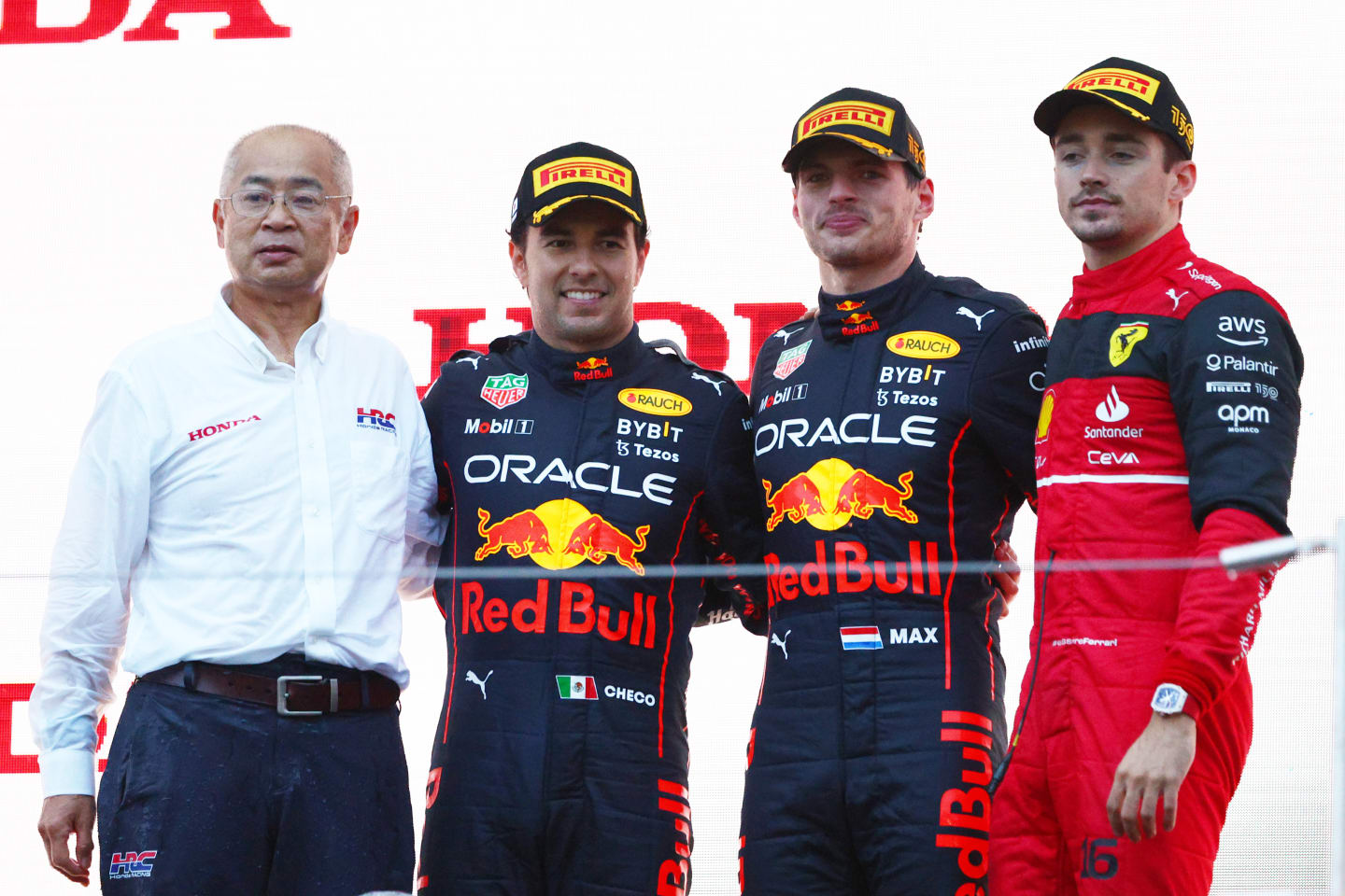SUZUKA, JAPAN - OCTOBER 09: Race winner and 2022 F1 World Drivers Champion Max Verstappen of Netherlands and Oracle Red Bull Racing (second from right), Second placed Sergio Perez of Mexico and Oracle Red Bull Racing (second from left) and Third placed Charles Leclerc of Monaco and Ferrari celebrate on the podium during the F1 Grand Prix of Japan at Suzuka International Racing Course on October 09, 2022 in Suzuka, Japan. (Photo by Clive Rose/Getty Images)