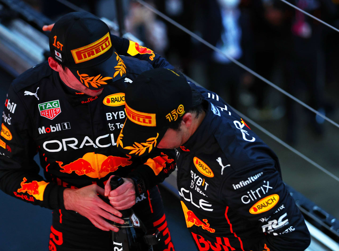 SUZUKA, JAPAN - OCTOBER 09: Race winner and 2022 F1 World Drivers Champion Max Verstappen of Netherlands and Oracle Red Bull Racing and Second placed Sergio Perez of Mexico and Oracle Red Bull Racing celebrate on the podium during the F1 Grand Prix of Japan at Suzuka International Racing Course on October 09, 2022 in Suzuka, Japan. (Photo by Mark Thompson/Getty Images )