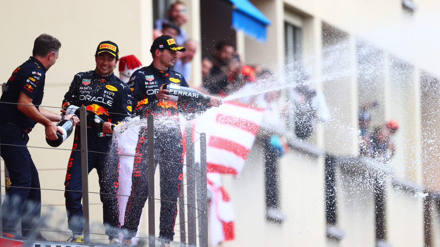 MONTE-CARLO, MONACO - MAY 29: Race winner Sergio Perez of Mexico and Oracle Red Bull Racing and Red Bull Racing Team Principal Christian Horner celebrate on the podium as Third placed Max Verstappen of the Netherlands and Oracle Red Bull Racing sprays sparkling wine during the F1 Grand Prix of Monaco at Circuit de Monaco on May 29, 2022 in Monte-Carlo, Monaco. (Photo by Dan Istitene - Formula 1/Formula 1 via Getty Images)