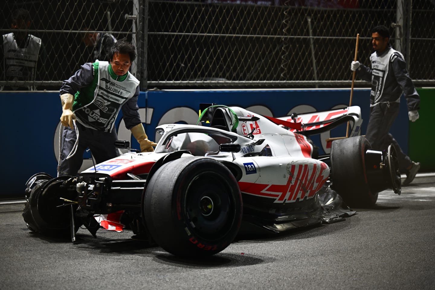 JEDDAH, SAUDI ARABIA - MARCH 26: Track marshals clean debris from the track following the crash of