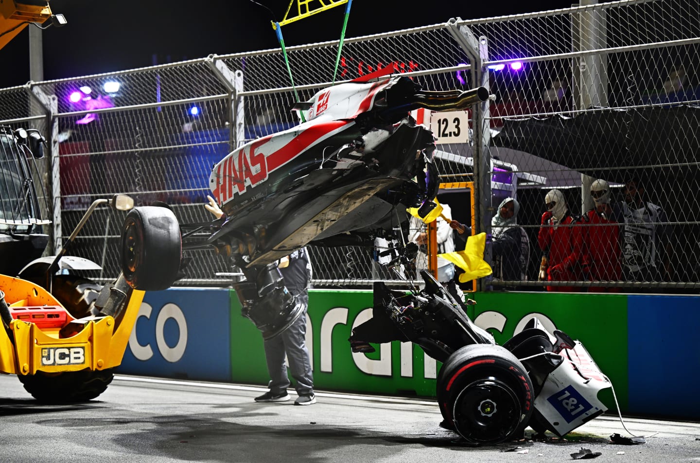 JEDDAH, SAUDI ARABIA - MARCH 26: Track marshals clean debris from the track following the crash of