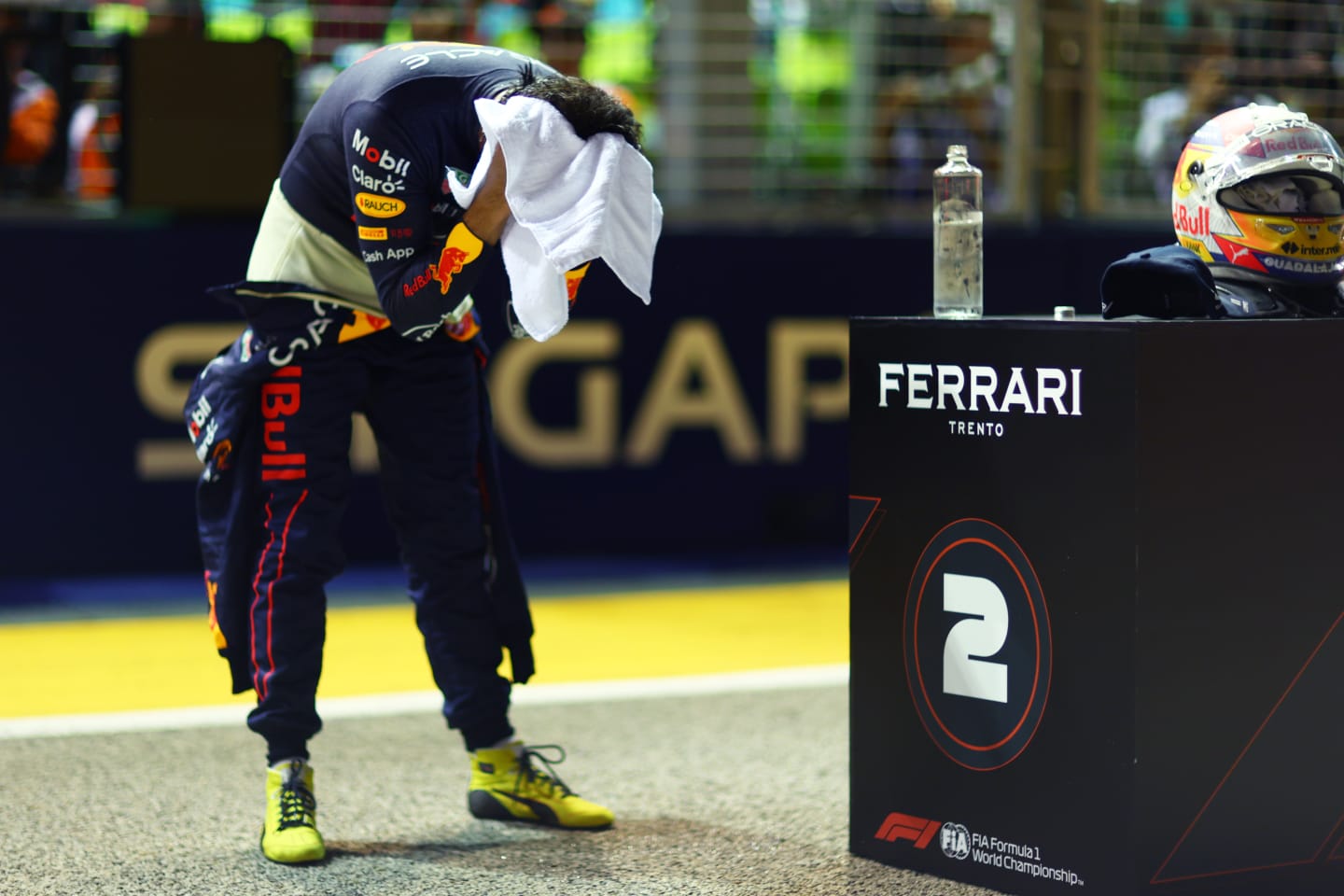 SINGAPORE, SINGAPORE - OCTOBER 01: Second placed qualifier Sergio Perez of Mexico and Oracle Red Bull Racing wipes his head with a towel in parc ferme during qualifying ahead of the F1 Grand Prix of Singapore at Marina Bay Street Circuit on October 01, 2022 in Singapore, Singapore. (Photo by Dan Istitene - Formula 1/Formula 1 via Getty Images)