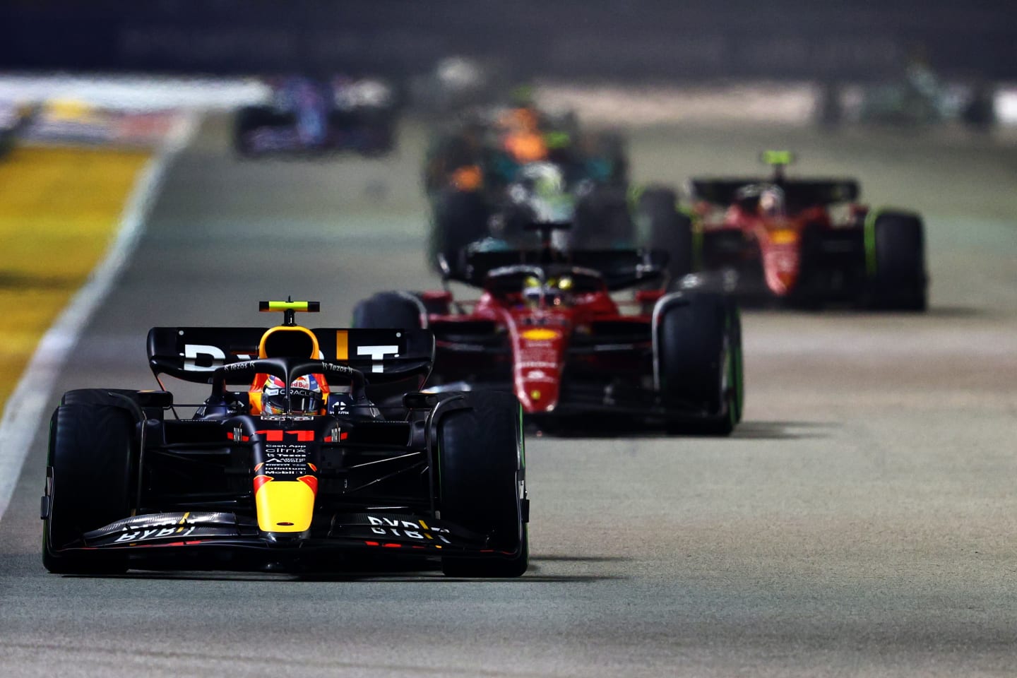 SINGAPORE, SINGAPORE - OCTOBER 02: Sergio Perez of Mexico driving the (11) Oracle Red Bull Racing RB18 leads Charles Leclerc of Monaco driving the (16) Ferrari F1-75 during the F1 Grand Prix of Singapore at Marina Bay Street Circuit on October 02, 2022 in Singapore, Singapore. (Photo by Clive Rose/Getty Images,)