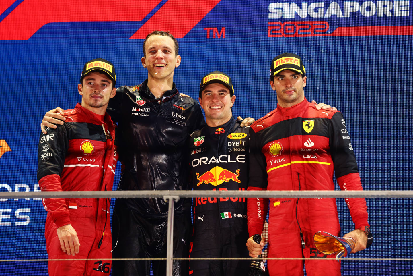 SINGAPORE, SINGAPORE - OCTOBER 02: Race winner Sergio Perez of Mexico and Oracle Red Bull Racing (second from right), Second placed Charles Leclerc of Monaco and Ferrari (L), Third placed Carlos Sainz of Spain and Ferrari (R) and Red Bull Racing race engineer Hugh Bird (second from left) celebrate on the podium during the F1 Grand Prix of Singapore at Marina Bay Street Circuit on October 02, 2022 in Singapore, Singapore. (Photo by Clive Rose/Getty Images,)