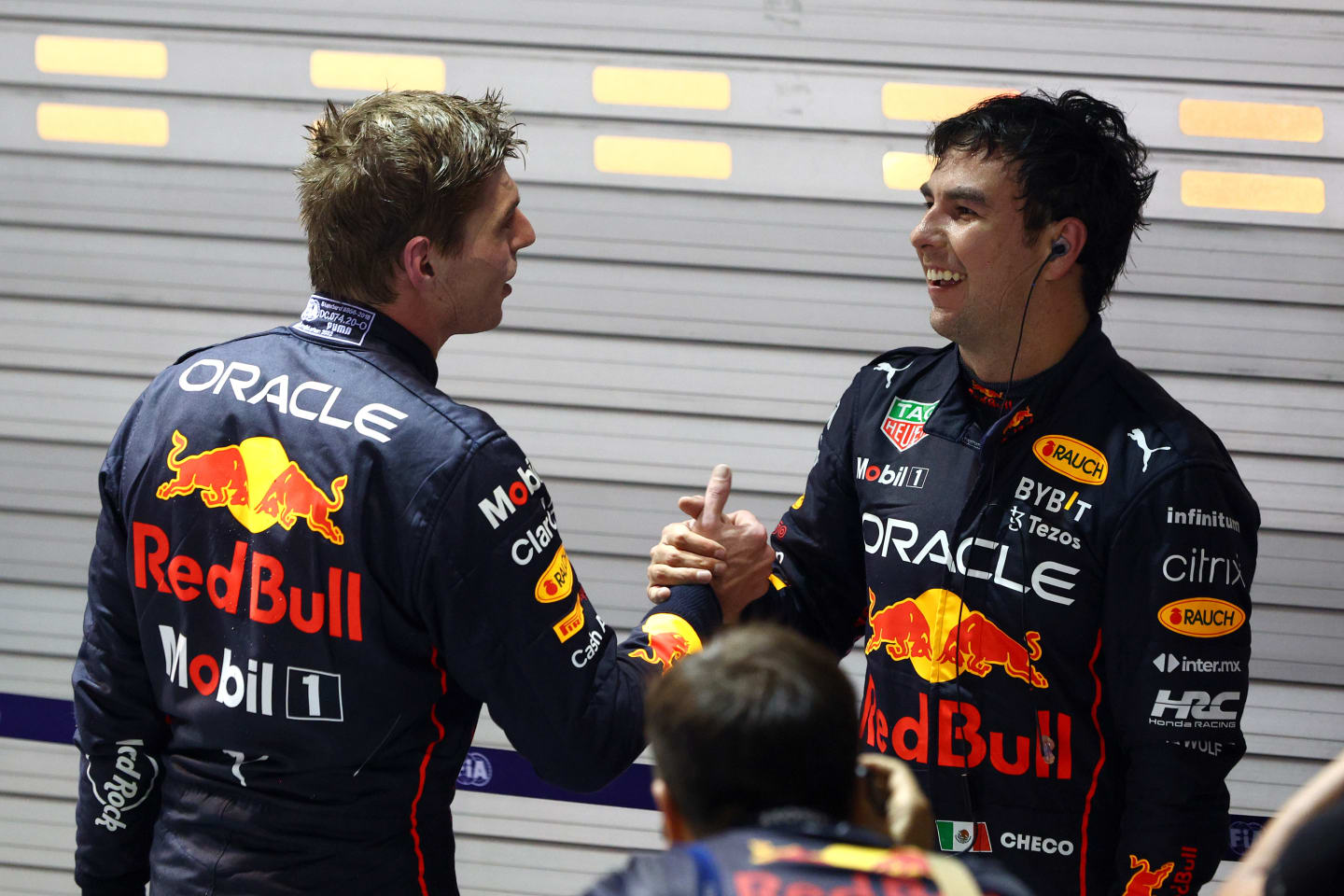 SINGAPORE, SINGAPORE - OCTOBER 02: Race winner Sergio Perez of Mexico and Oracle Red Bull Racing is congratulated by seventh placed Max Verstappen of the Netherlands and Oracle Red Bull Racing in parc ferme during the F1 Grand Prix of Singapore at Marina Bay Street Circuit on October 02, 2022 in Singapore, Singapore. (Photo by Clive Rose/Getty Images,)