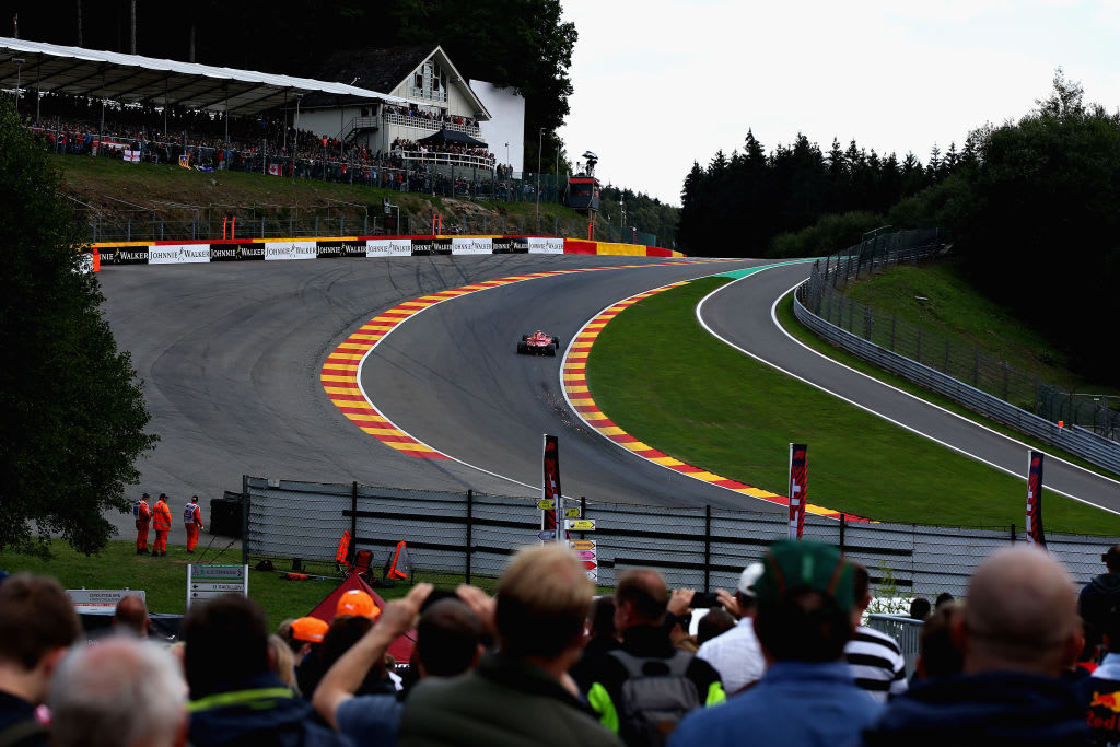 SPA, BELGIUM - AUGUST 25: Fans watch as sparks fly behind Kimi Raikkonen of Finland driving the (7)