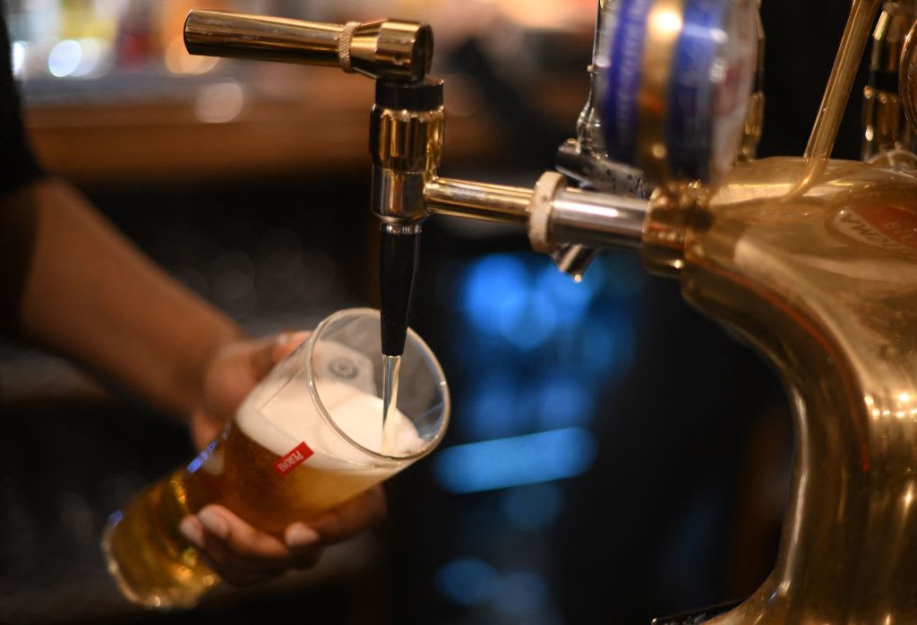 An employee pours a pint of Peroni beer on at the bar in the Mad Hatter pub and hotel, operated by