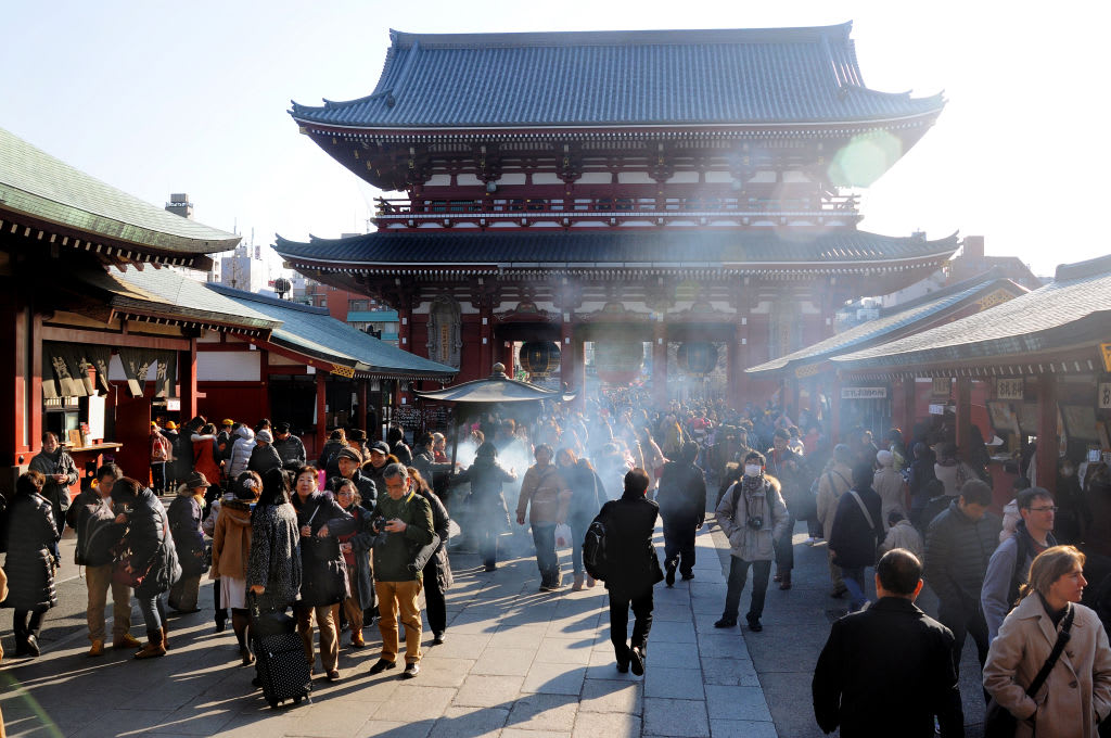TOKYO, JAPAN - JANUARY 16, 2014: Visitors gather and burn incense in front of Asakusa Kannon