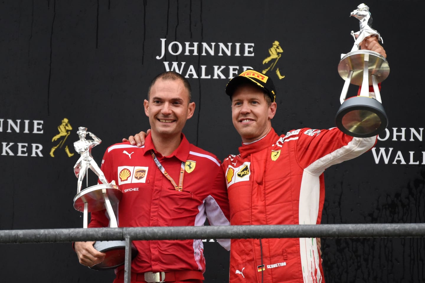 Winner Ferrari's German driver Sebastian Vettel (R) celebrates on the podium with Ferrari
