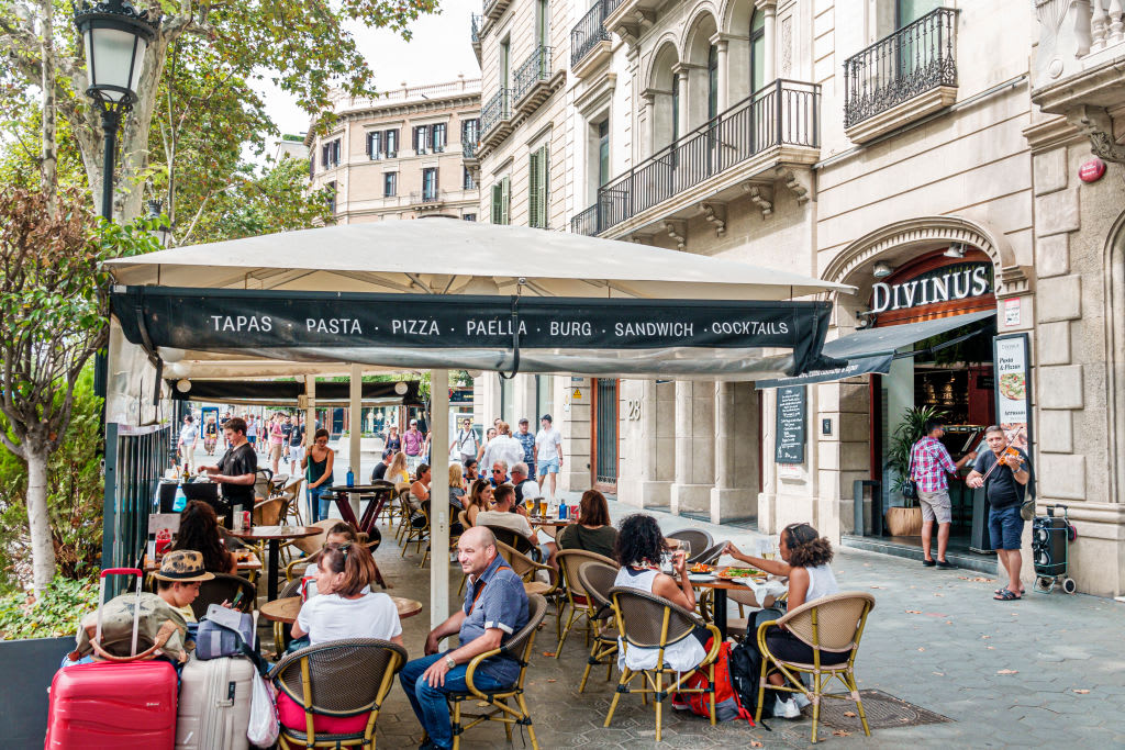 Spain, Barcelona, Passeig de Gracia, shopping district, Divinus, tapas bar outdoor tables. (Photo