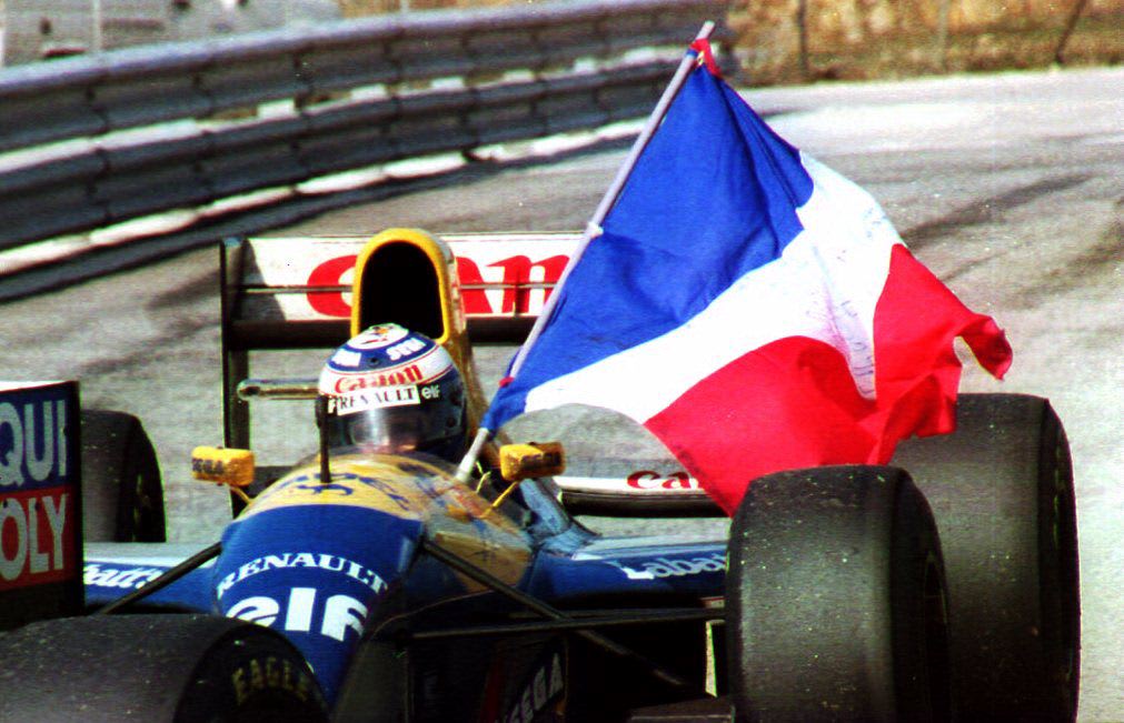 French Formula one driver Alain Prost holds his country's flag after clinching on Williams-Renault