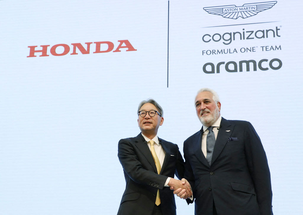 Honda Motor President Toshihiro Mibe (L) shakes hands with Aston Martin F1 executive chairman