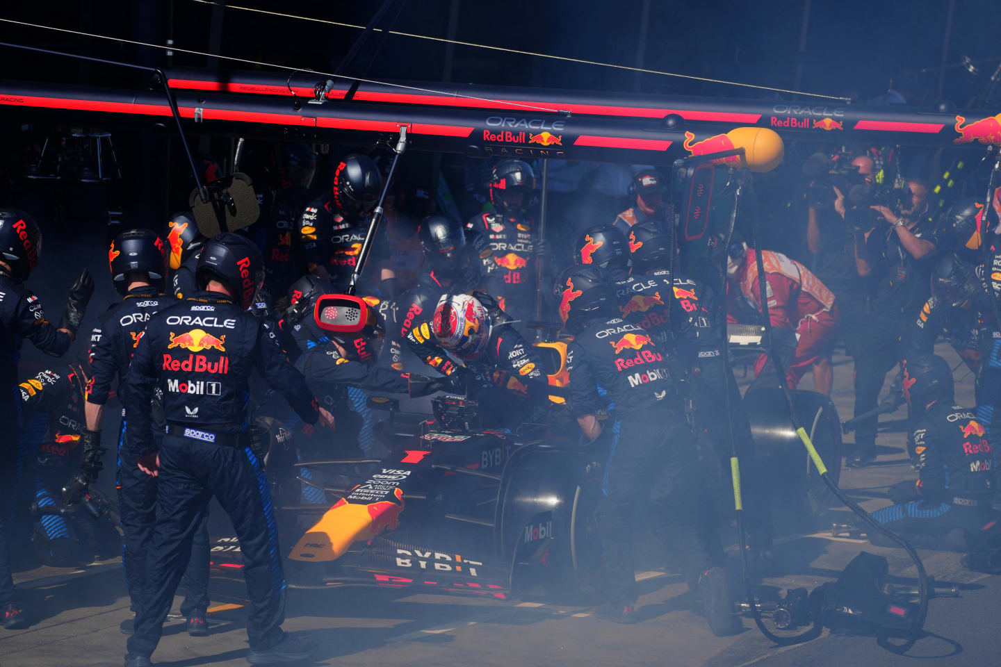 Red Bull Racing's Dutch driver Max Verstappen (C) comes out after smoke billowing from his car