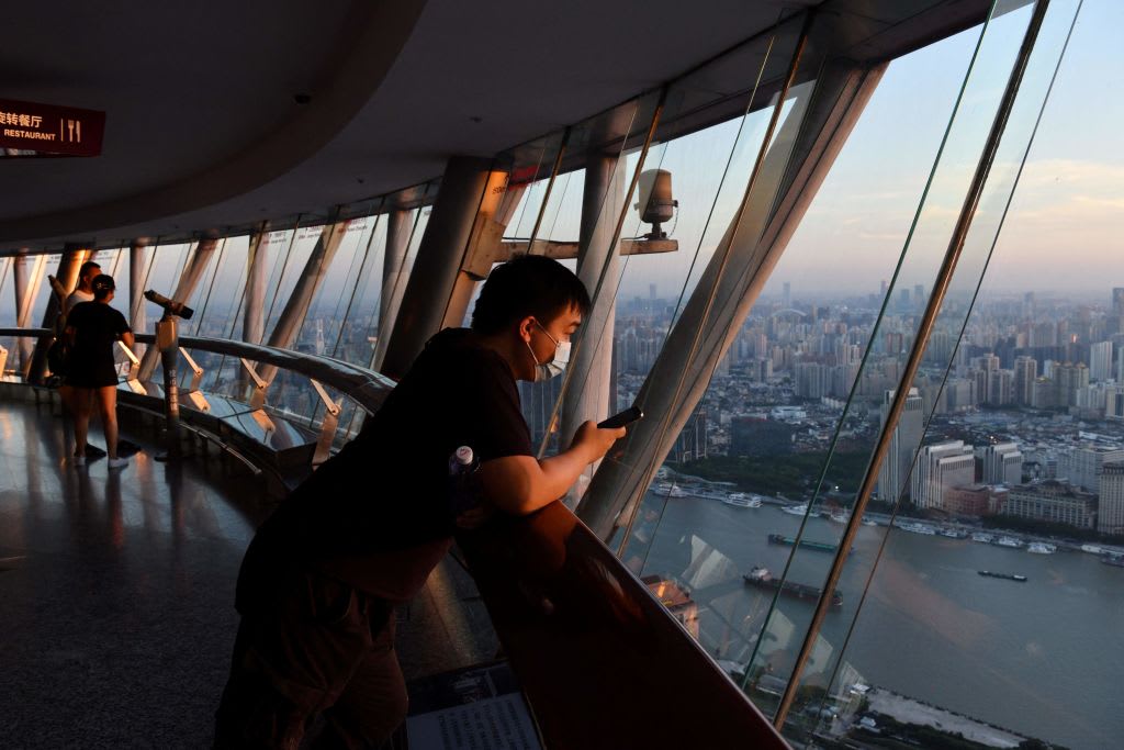 A man looks at the view from the Oriental Pearl Tower at sunset in Shanghai on August 31, 2021.