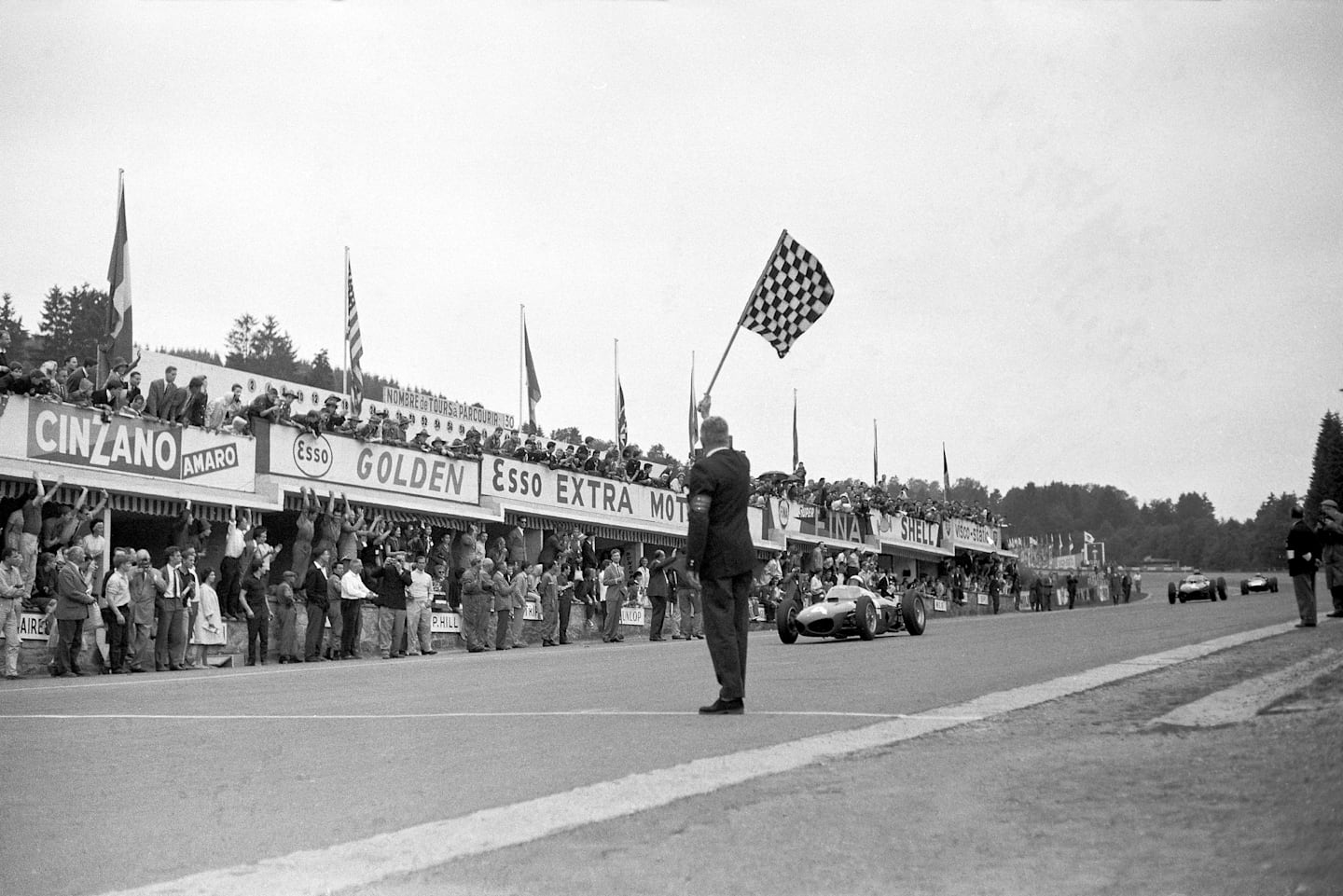 American racing driver Phil Hill takes the checkered flag at the Belgian Grand Prix, for another