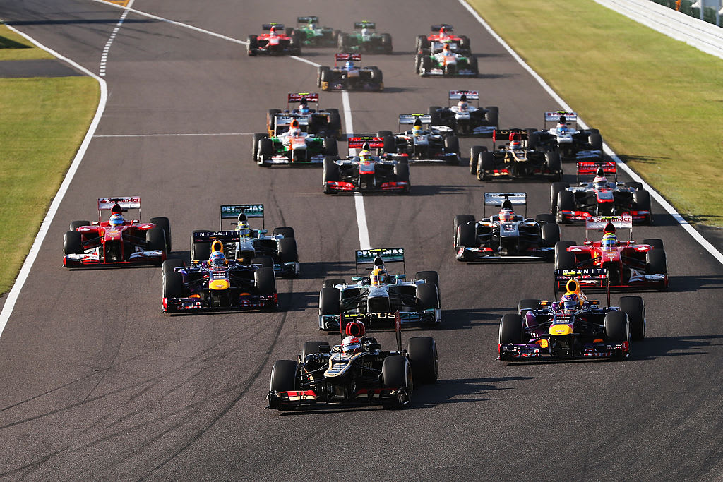 SUZUKA, JAPAN - OCTOBER 13:  Romain Grosjean (C) of France and Lotus takes the lead at the start of