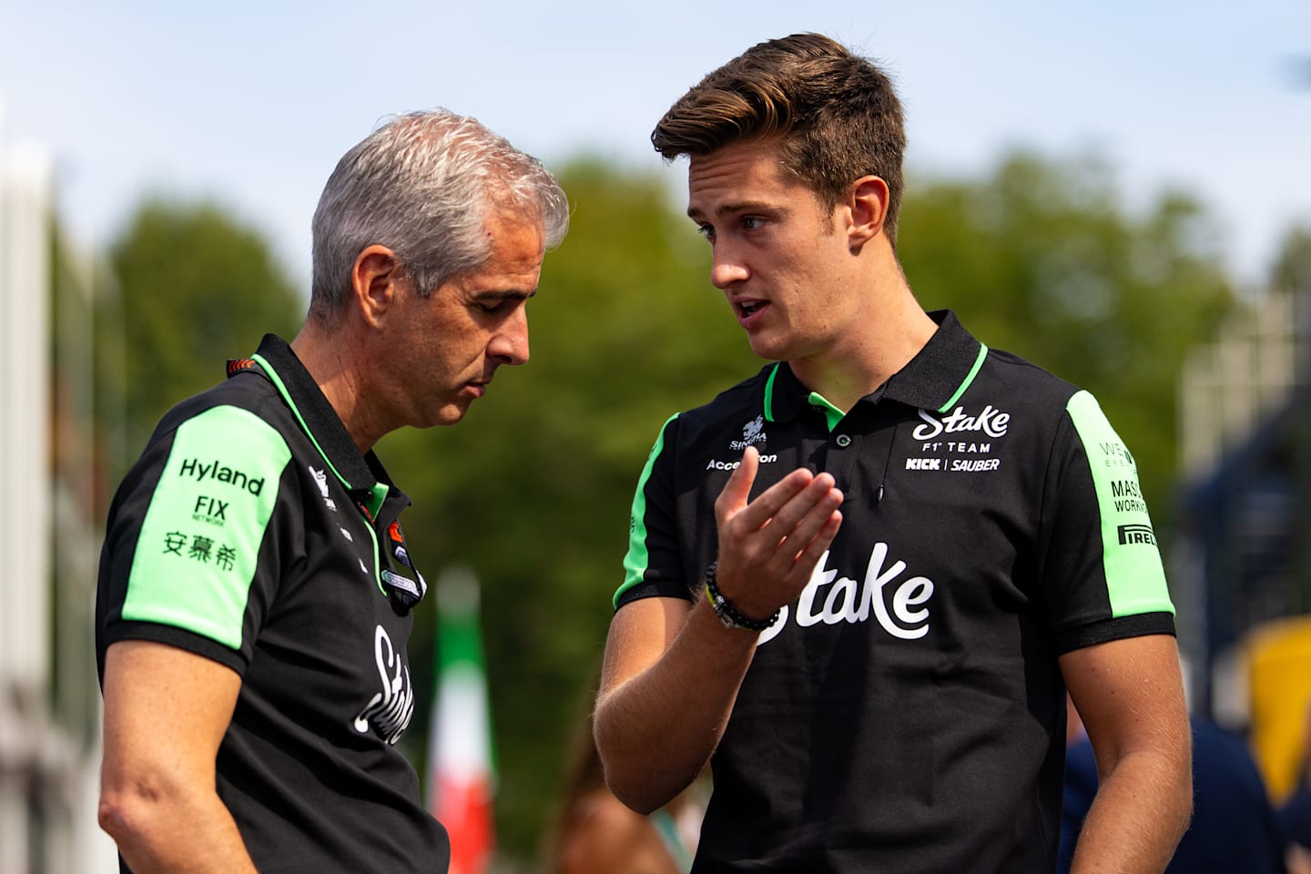 MONZA, ITALY - AUGUST 31: Alessandro Alunni Bravi, Team Representative of Stake F1 Team Kick Sauber speaks with reserve driver, Theo Pourchaire in the paddock during qualifying ahead of the F1 Grand Prix of Italy. (Photo by Kym Illman/Getty Images)