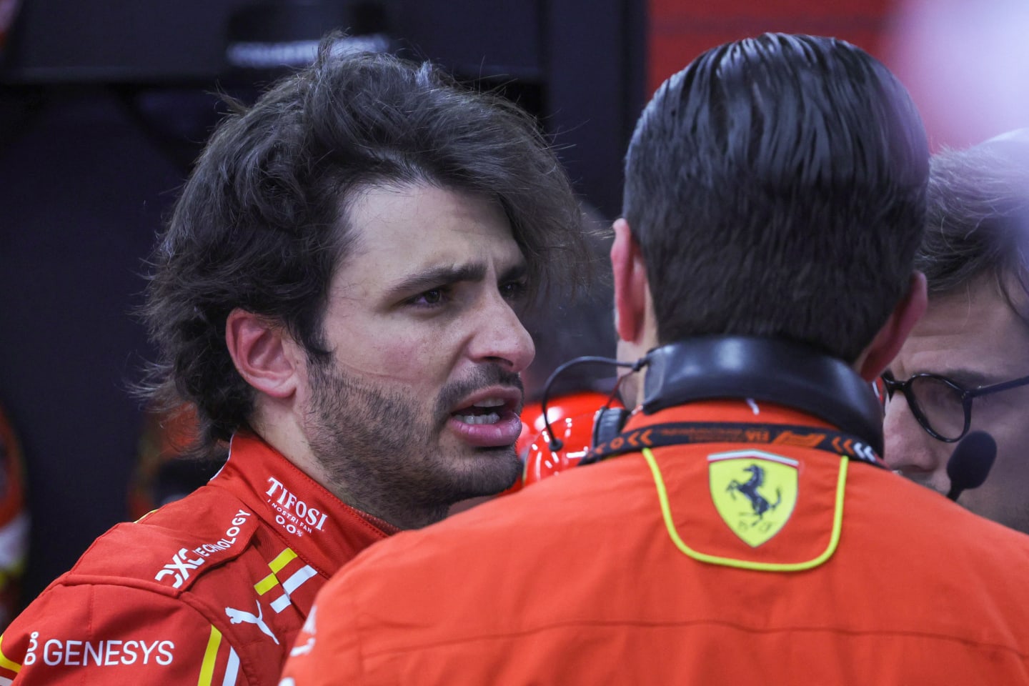 Ferrari's Spanish driver Carlos Sainz Jr talks to team members in the garage after the first