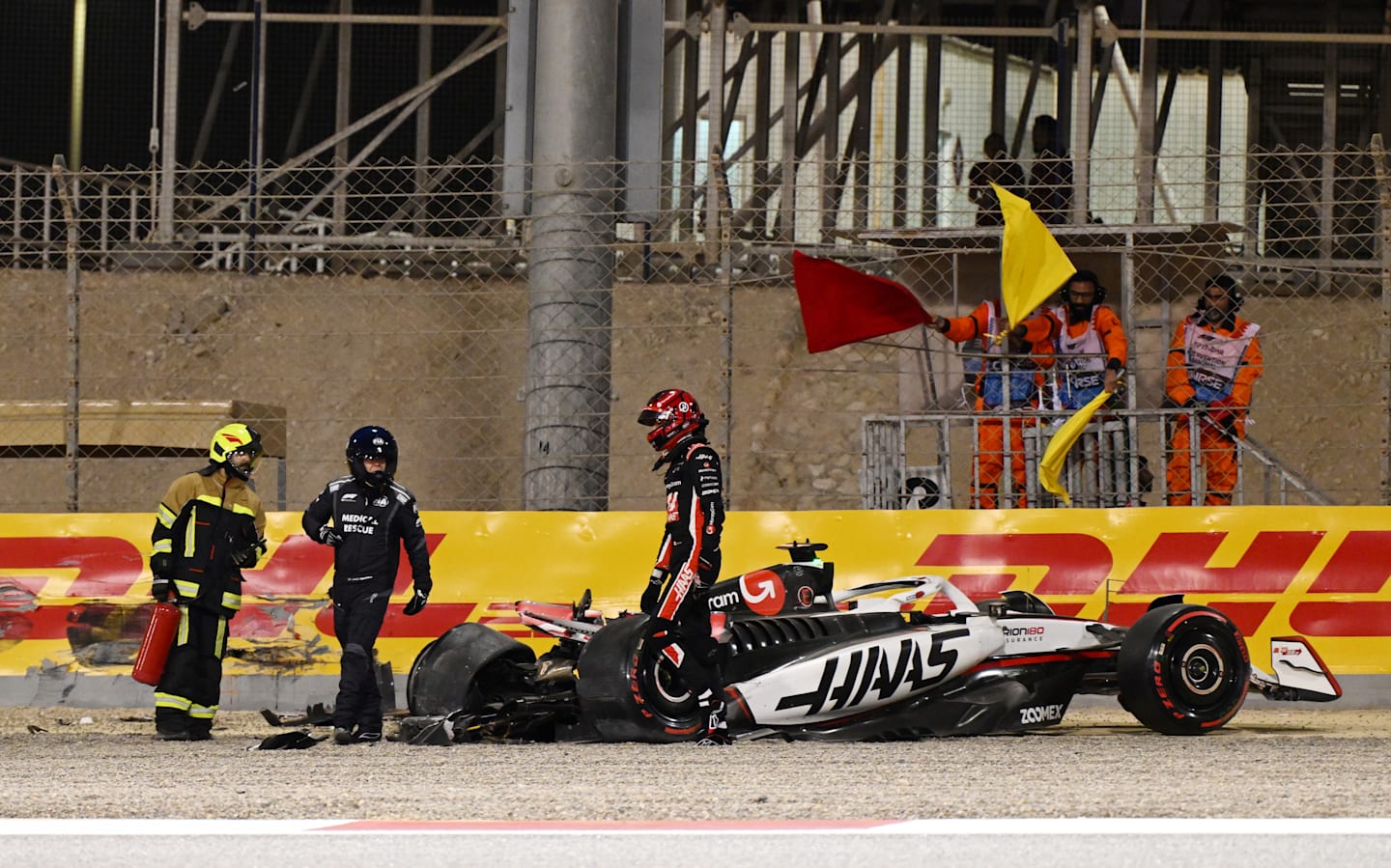 BAHRAIN, BAHRAIN - APRIL 12: Marshals assist Esteban Ocon of France and Haas F1 after a crash