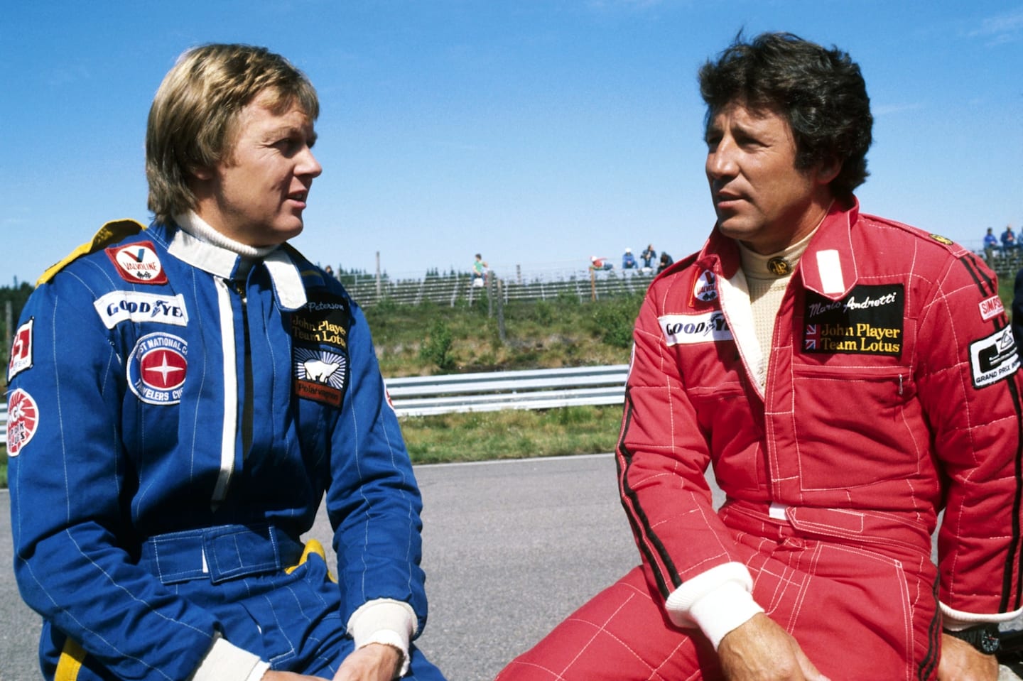 (L to R): Third placed Ronnie Peterson (SWE) talks with his Lotus team mate Mario Andretti (USA),