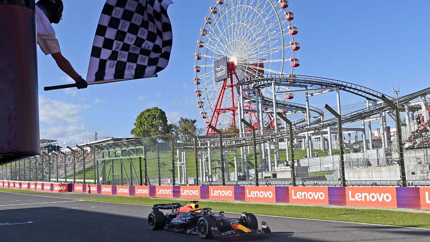 TOPSHOT - Red Bull Racing's Dutch driver Max Verstappen is greeted by the checkered flag as he wins