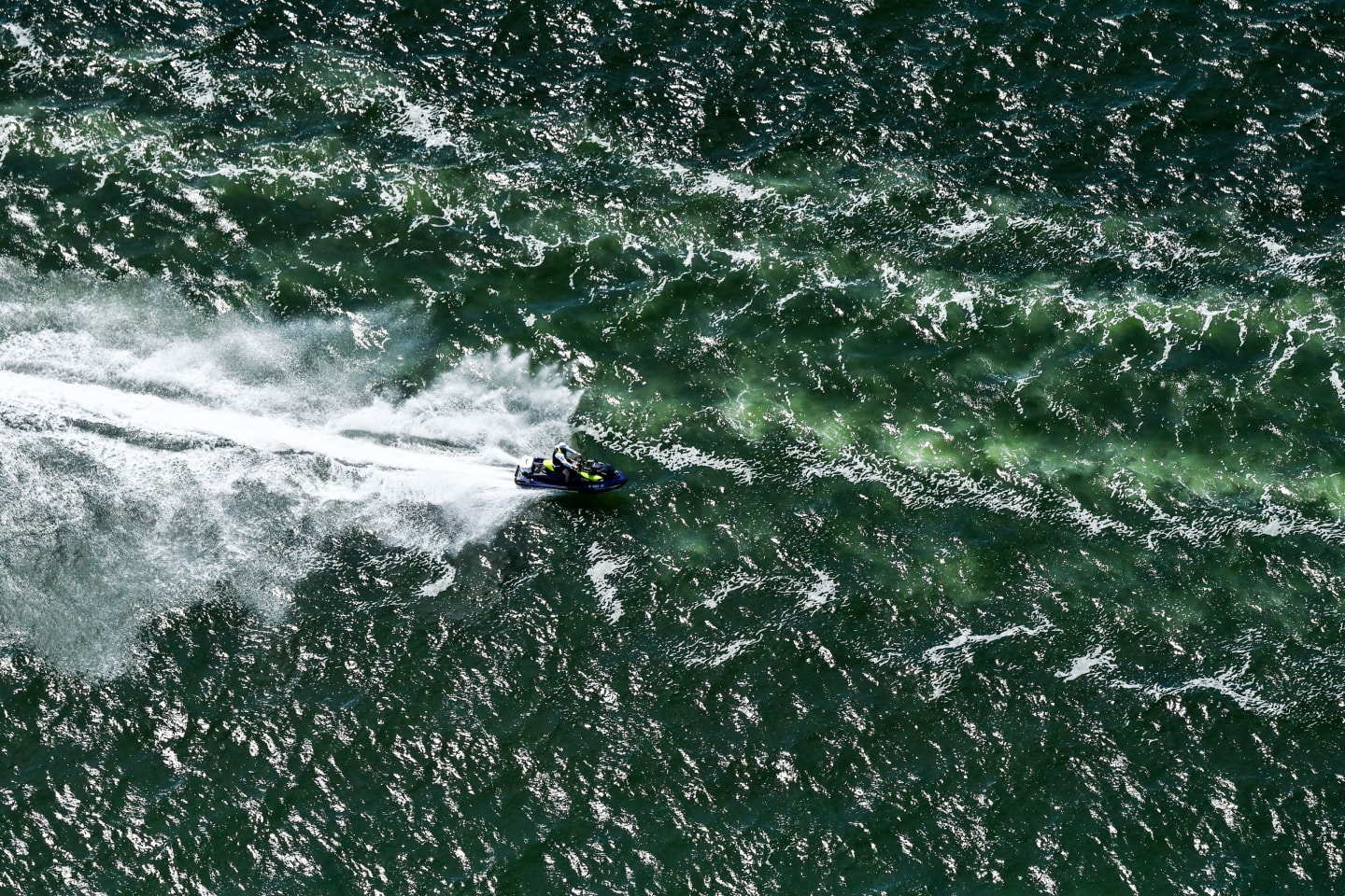 An aerial view of a man riding a jet-ski in the bay of Miami Beach, Florida on June 27, 2021.