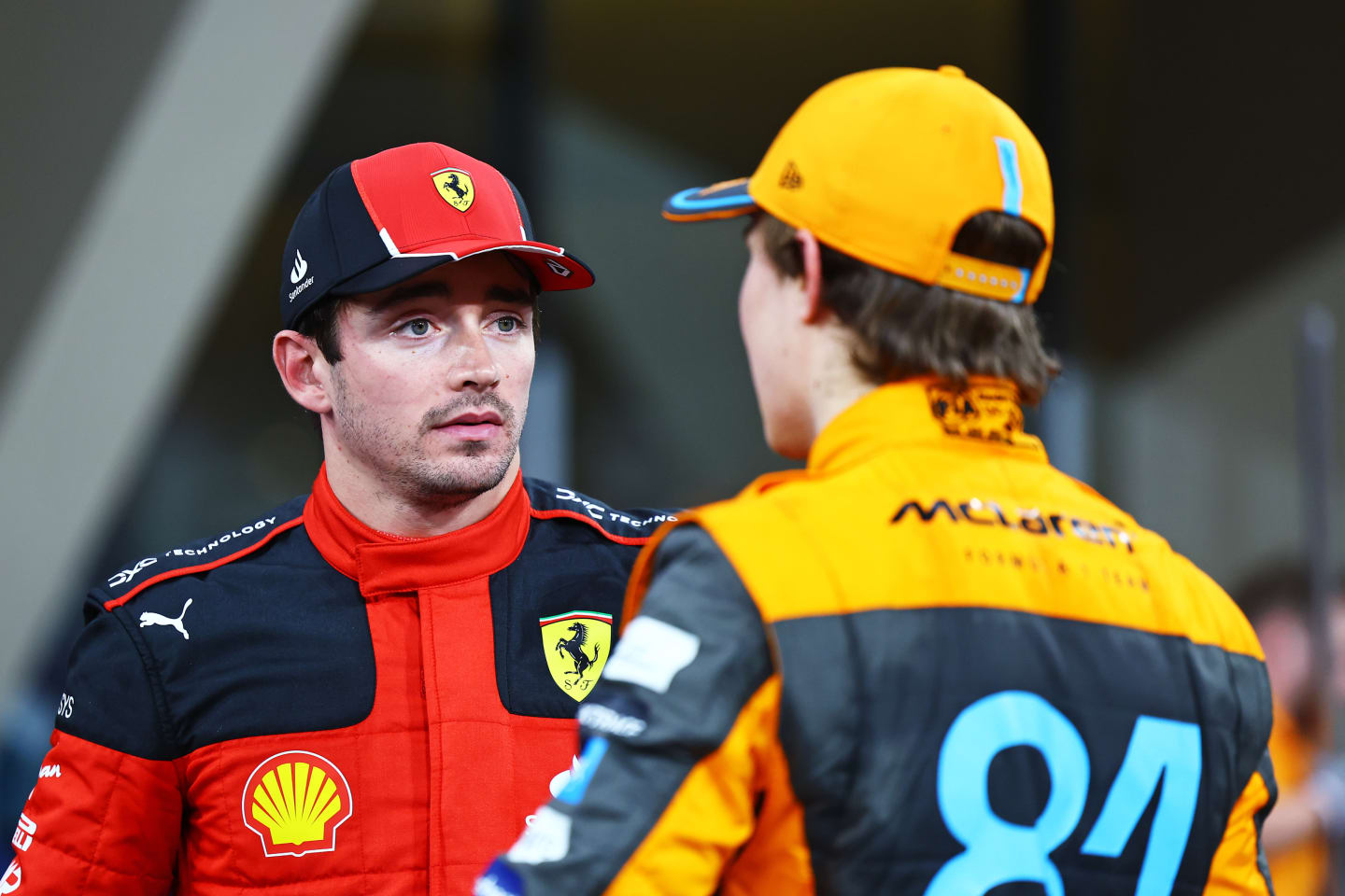 ABU DHABI, UNITED ARAB EMIRATES - NOVEMBER 25: Second placed qualifier Charles Leclerc of Monaco and Ferrari and Third placed qualifier Oscar Piastri of Australia and McLaren talk in parc ferme during qualifying ahead of the F1 Grand Prix of Abu Dhabi at Yas Marina Circuit on November 25, 2023 in Abu Dhabi, United Arab Emirates. (Photo by Mark Thompson/Getty Images)