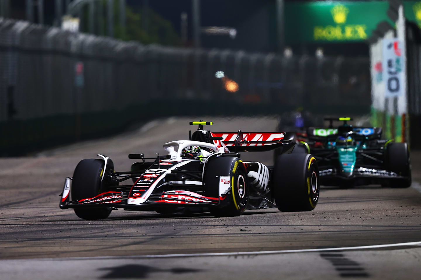 SINGAPORE, SINGAPORE - SEPTEMBER 22: Nico Hulkenberg of Germany driving the (27) Haas F1 VF-24 Ferrari leads Fernando Alonso driving the (14) Aston Martin AMR24 Mercedes on track during the F1 Grand Prix of Singapore. (Photo by Joe Portlock/Getty Images)