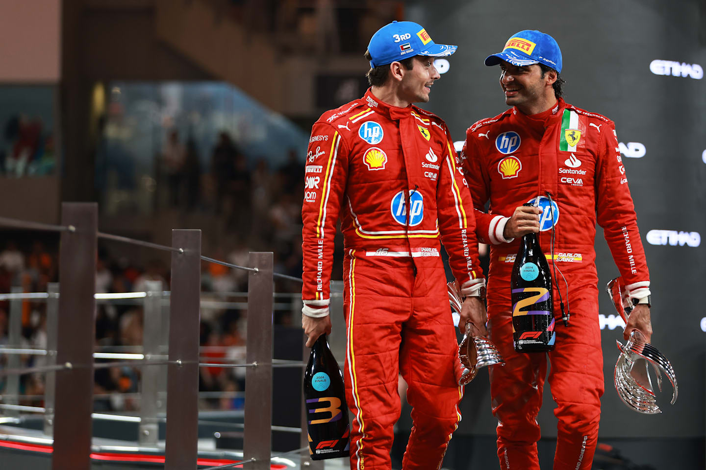 Carlos Sainz and Third placed Charles Leclerc celebrate on the podium during the F1 Grand Prix of Abu Dhabi at Yas Marina Circuit on December 08, 2024 in Abu Dhabi, United Arab Emirates. (Photo by Bryn Lennon - Formula 1/Formula 1 via Getty Images)