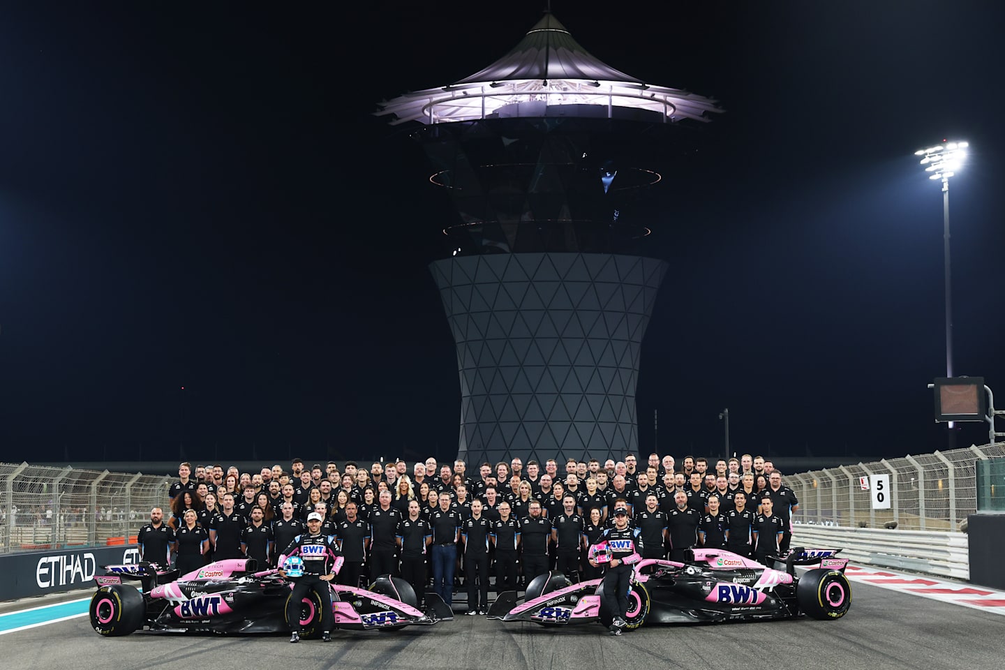 Pierre Gasly and Jack Doohan pose with their team after qualifying ahead of the F1 Grand Prix of Abu Dhabi at Yas Marina Circuit on December 07, 2024 in Abu Dhabi, United Arab Emirates. (Photo by Bryn Lennon - Formula 1/Formula 1 via Getty Images)