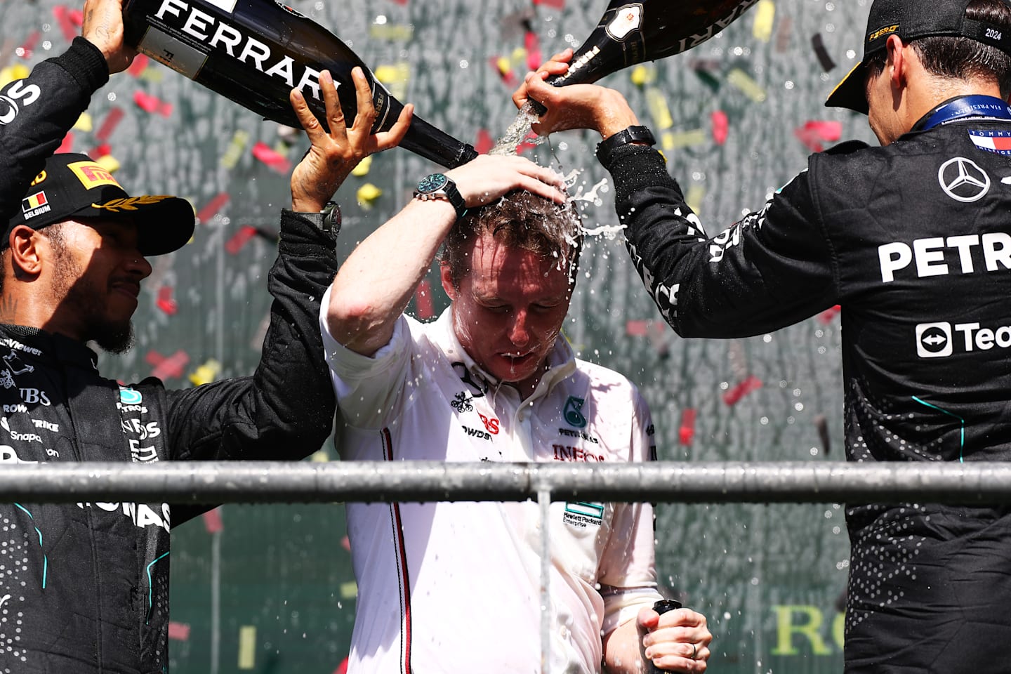 SPA, BELGIUM - JULY 28: Race winner George Russell of Great Britain and Mercedes (R), Second placed Lewis Hamilton of Great Britain and Mercedes (L) and Lead Race Stragegist of Mercedes (C) celebrate on the podium during the F1 Grand Prix of Belgium at Circuit de Spa-Francorchamps on July 28, 2024 in Spa, Belgium. (Photo by Peter Fox - Formula 1/Formula 1 via Getty Images)