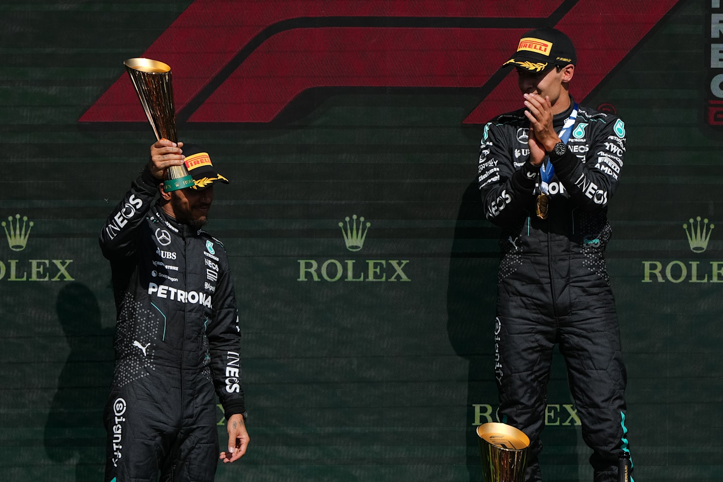 SPA, BELGIUM - JULY 28: 1st placed finisher George Russell, later disqualified for a car weight infraction (R), Lewis Hamilton celebrate on the podium during the F1 Grand Prix of Belgium. (Photo by Alex Bierens de Haan/Getty Images)