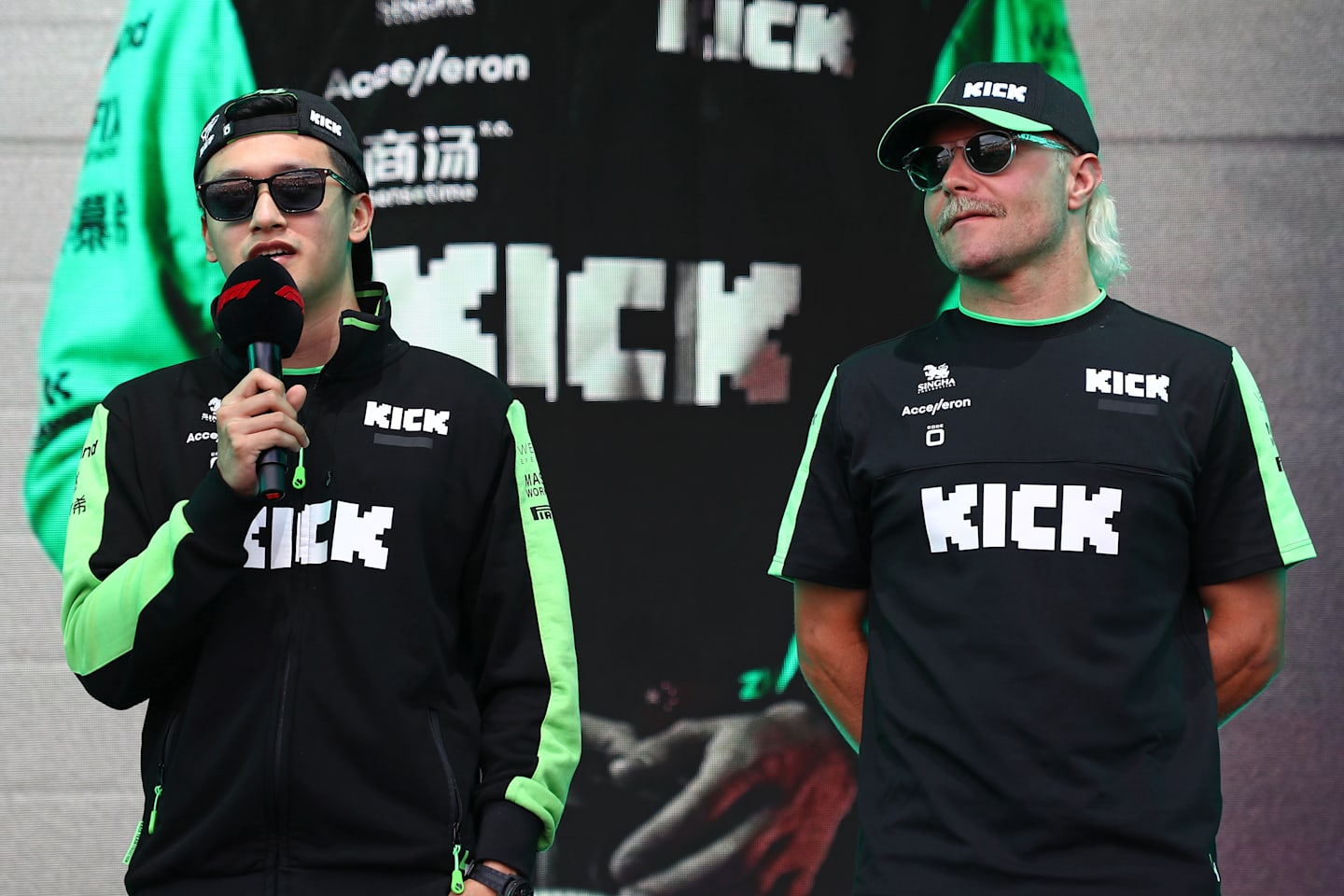 SPA, BELGIUM - JULY 26:  Zhou Guanyu of China and Stake F1 Team Kick Sauber and Valtteri Bottas of Finland and Stake F1 Team Kick Sauber talk to the crowd on the fan stage. (Photo by Peter Fox - Formula 1/Formula 1 via Getty Images)