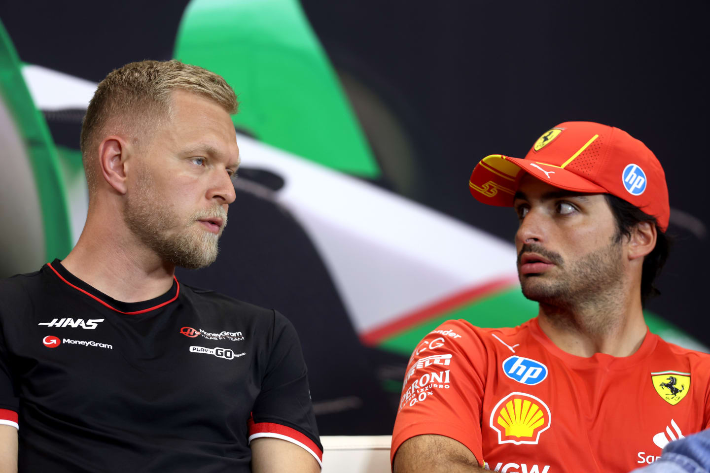 IMOLA, ITALY - MAY 16: Kevin Magnussen of Denmark and Haas F1 and Carlos Sainz of Spain and Ferrari talk in the Drivers Press Conference during previews ahead of the F1 Grand Prix of Emilia-Romagna at Autodromo Enzo e Dino Ferrari Circuit on May 16, 2024 in Imola, Italy. (Photo by Lars Baron/Getty Images)