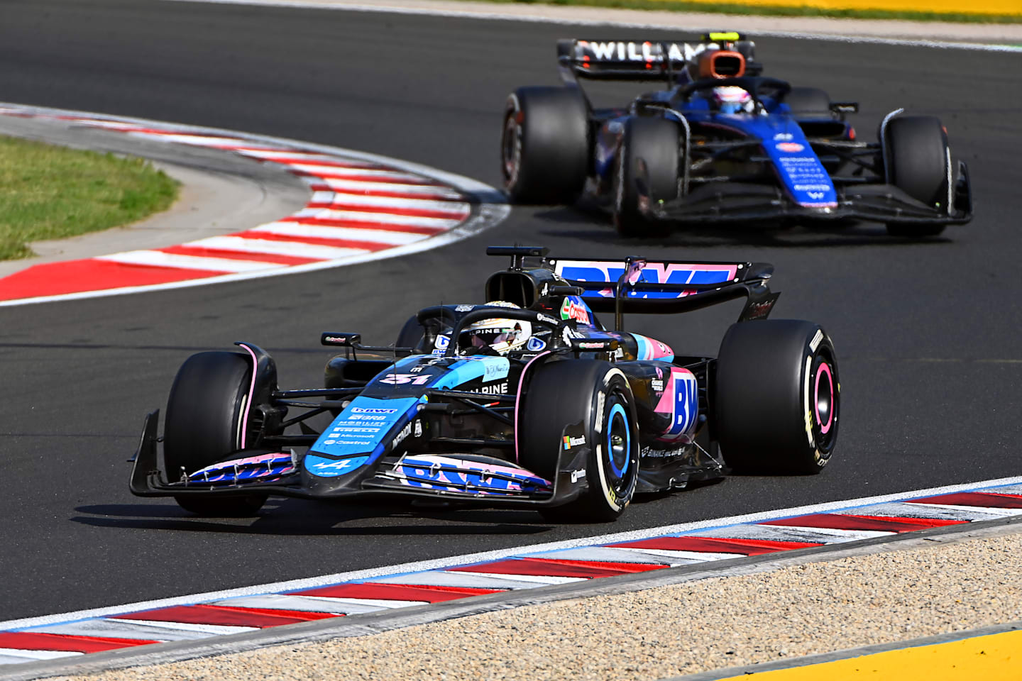 BUDAPEST, HUNGARY - JULY 21: Esteban Ocon of France driving the (31) Alpine F1 A524 Renault leads Logan Sargeant of United States driving the (2) Williams FW46 Mercedes on track  during the F1 Grand Prix of Hungary at Hungaroring on July 21, 2024 in Budapest, Hungary. (Photo by James Sutton - Formula 1/Formula 1 via Getty Images)