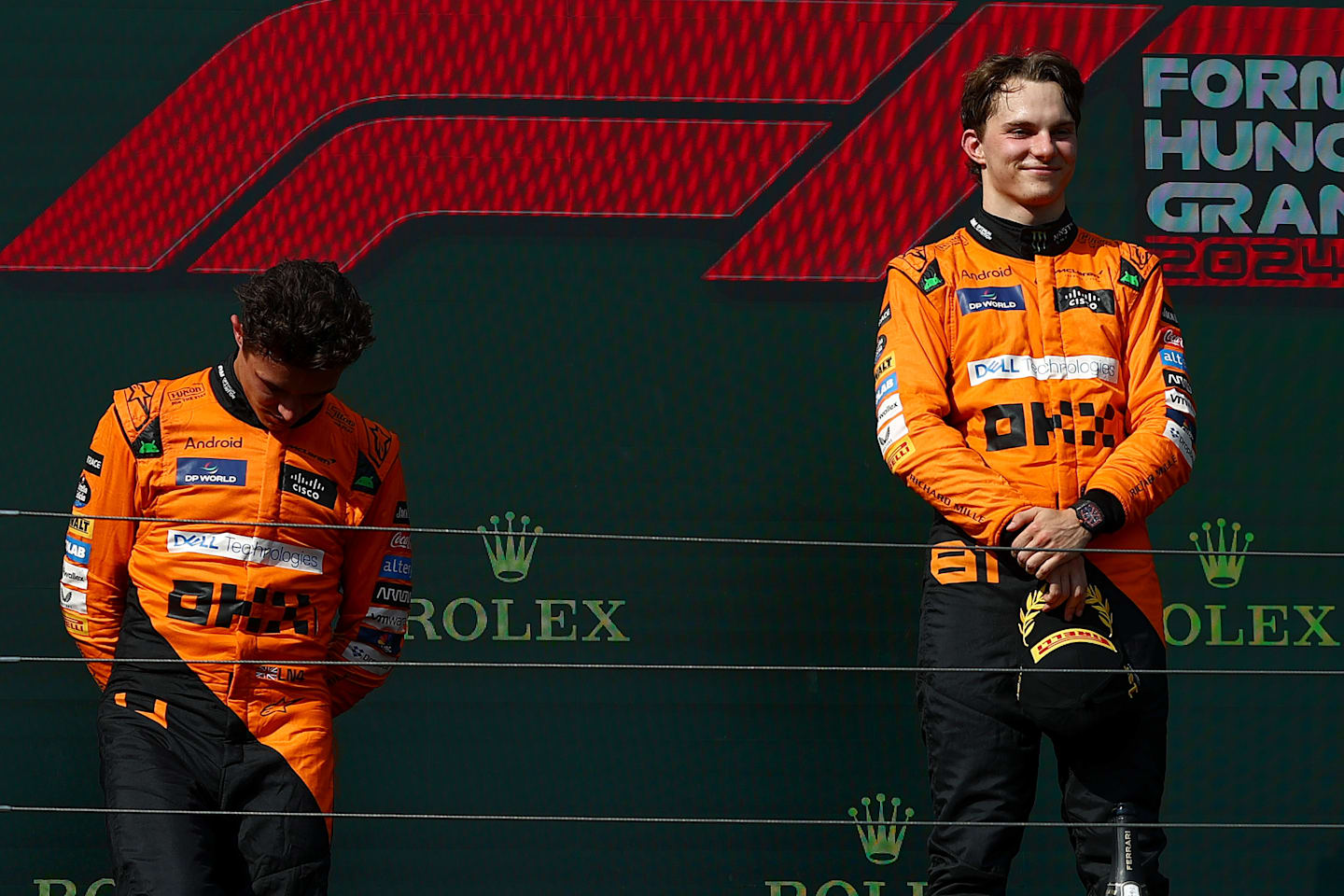 BUDAPEST, HUNGARY - JULY 21:Race winner Oscar Piastri of Australia and McLaren and Second placed Lando Norris of Great Britain and McLaren stand on the podium during the F1 Grand Prix of Hungary at Hungaroring on July 21, 2024 in Budapest, Hungary. (Photo by Joe Portlock - Formula 1/Formula 1 via Getty Images)