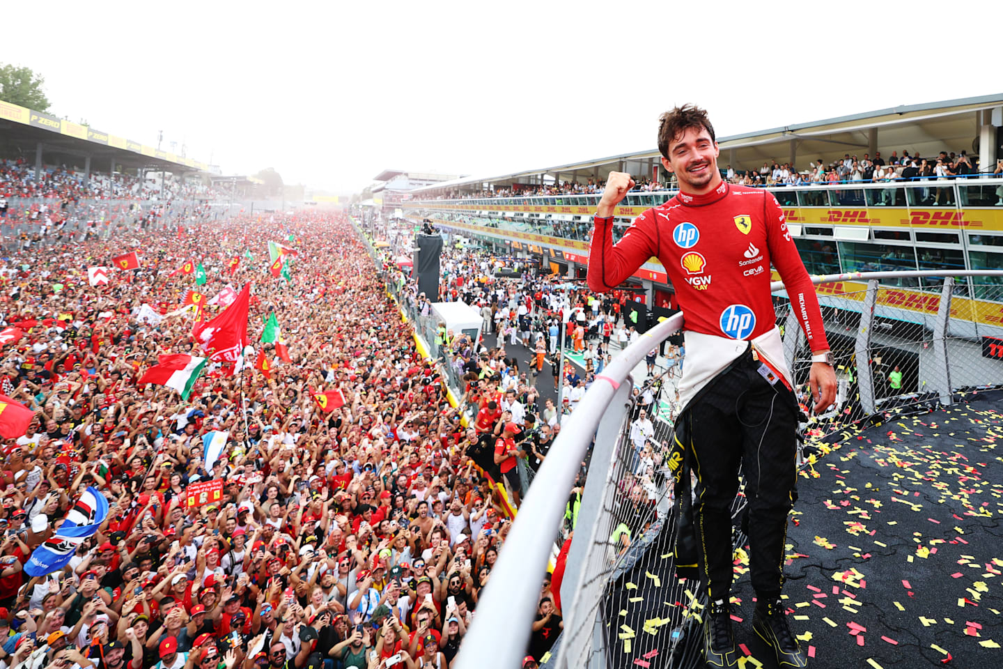 MONZA, ITALY - SEPTEMBER 01: Race winner Charles Leclerc of Monaco and Ferrari poses for a picture on the podium, with the fans down on the track during the F1 Grand Prix of Italy at Autodromo Nazionale Monza on September 01, 2024 in Monza, Italy. (Photo by Bryn Lennon - Formula 1/Formula 1 via Getty Images)