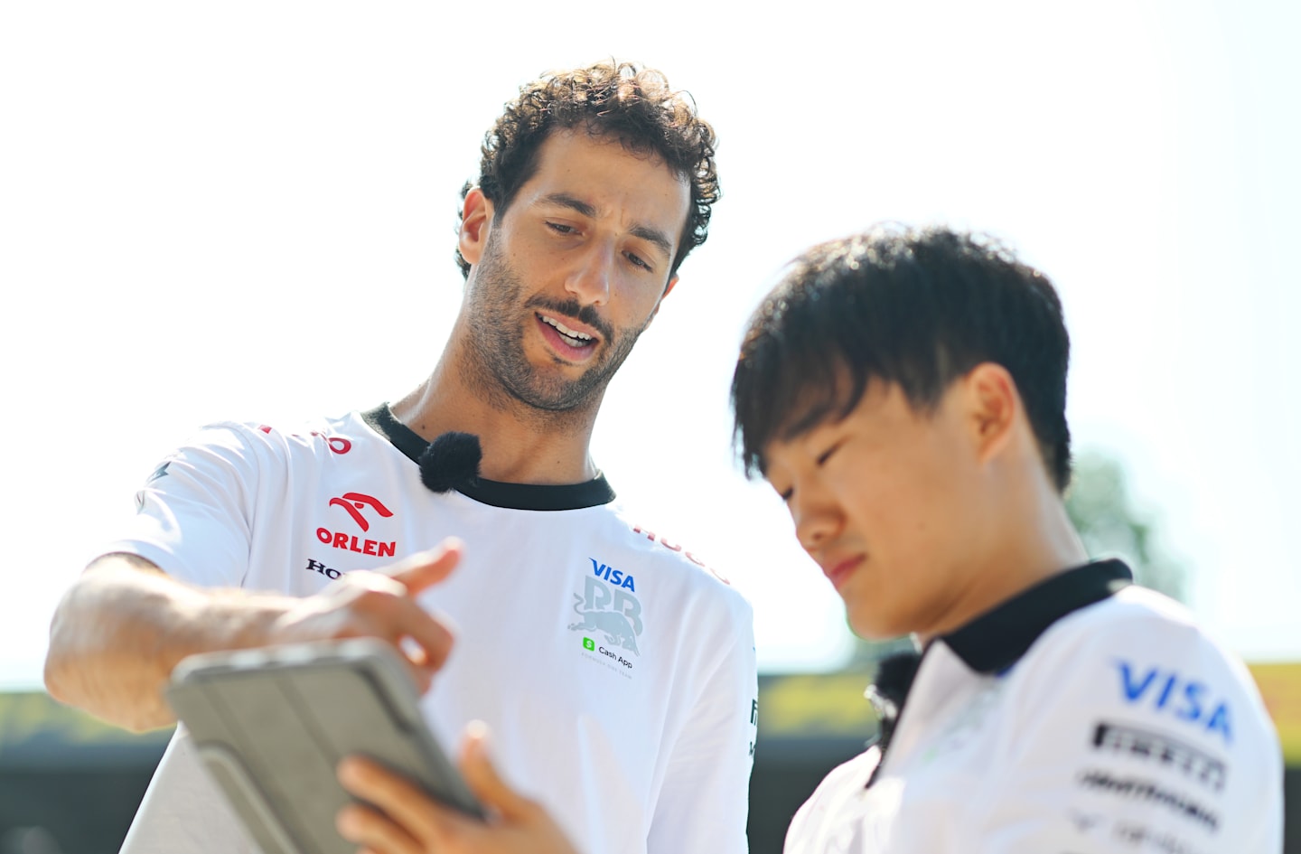 MONZA, ITALY - AUGUST 29: Daniel Ricciardo of Australia and Visa Cash App RB and Yuki Tsunoda of Japan and Visa Cash App RB look on in the pit lane during previews ahead of the F1 Grand Prix of Italy. (Photo by Rudy Carezzevoli/Getty Images)