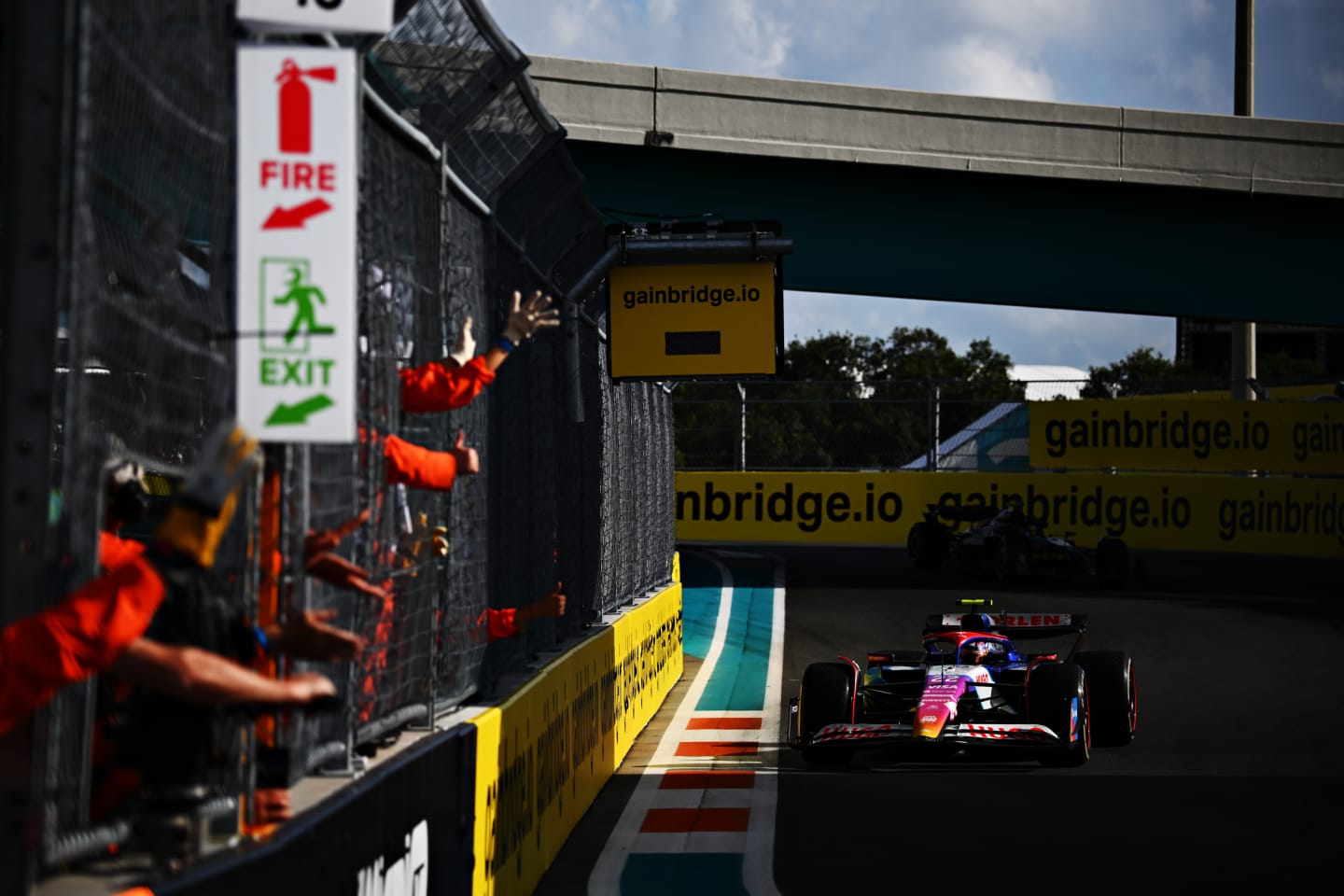 MIAMI, FLORIDA - MAY 05: Marshals wave and celebrate as Yuki Tsunoda of Japan driving the (22) Visa